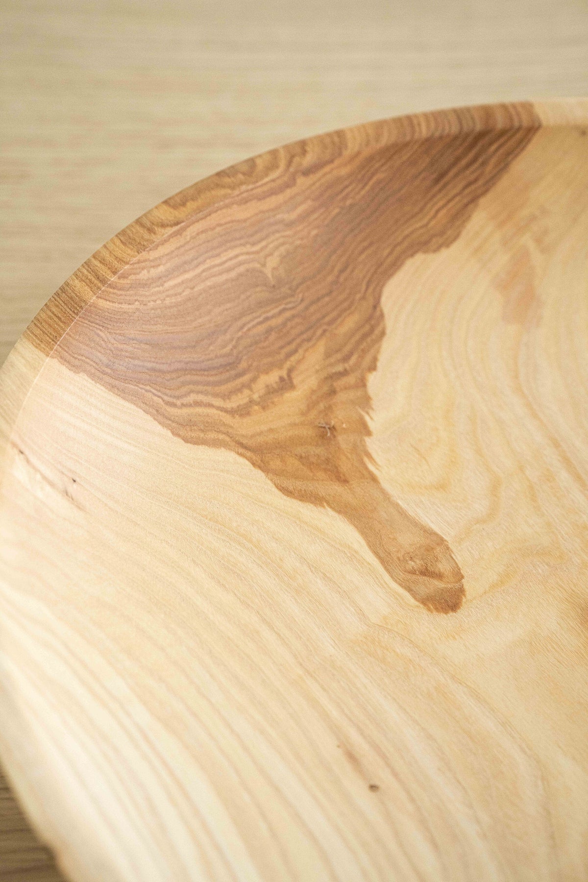 Hand-carved shallow ash wood fruit bowl with natural color gradient and 16-inch diameter