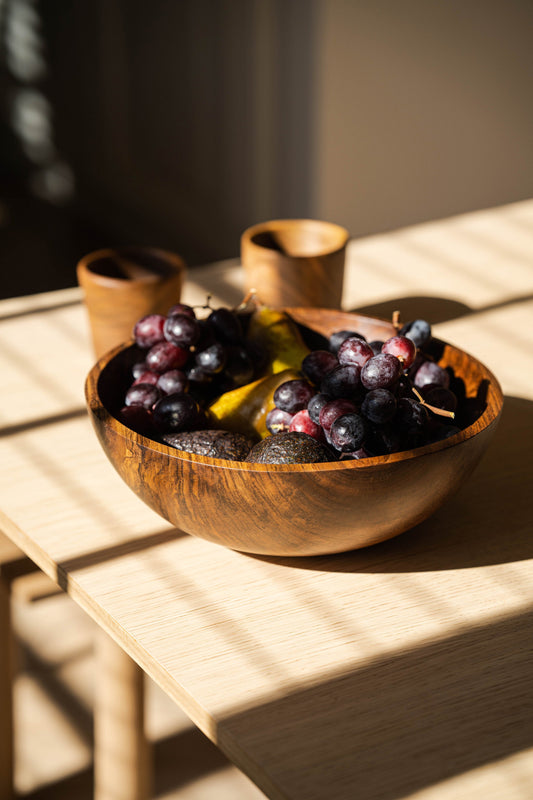 Hand-carved large walnut wood bowl with natural dark color and smooth finish, ideal for fruit display