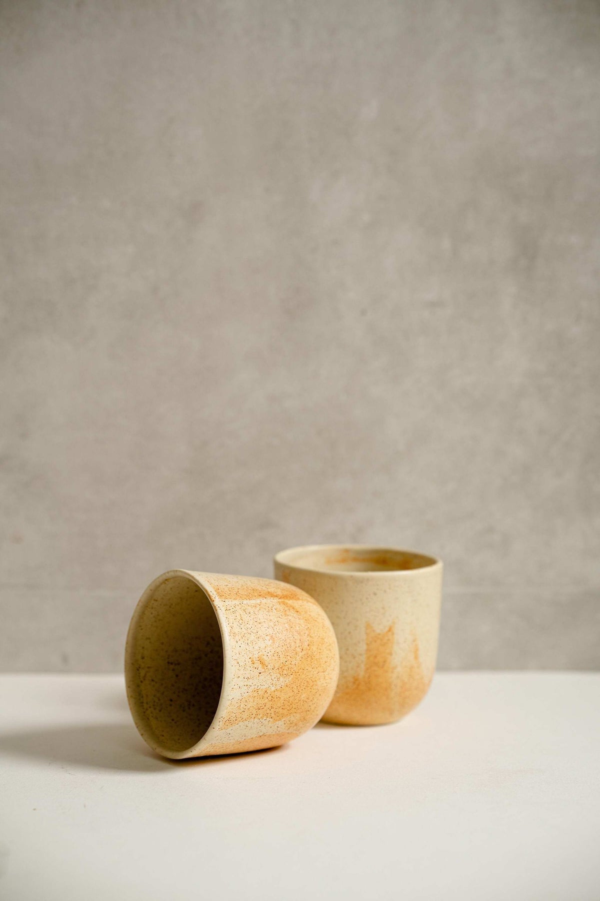 Handmade stoneware beige coffee cup with organic edges and unique reactive glaze swirl, 11 oz, dishwasher and microwave safe.