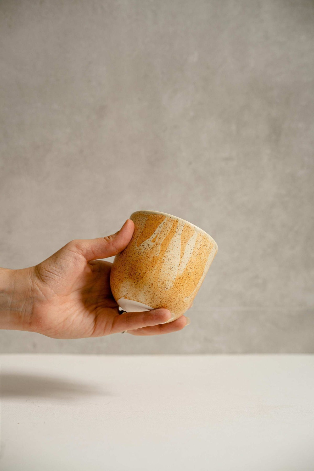 Handmade stoneware beige coffee cup with organic edges and reactive glaze swirl, 11 oz, durable and dishwasher safe