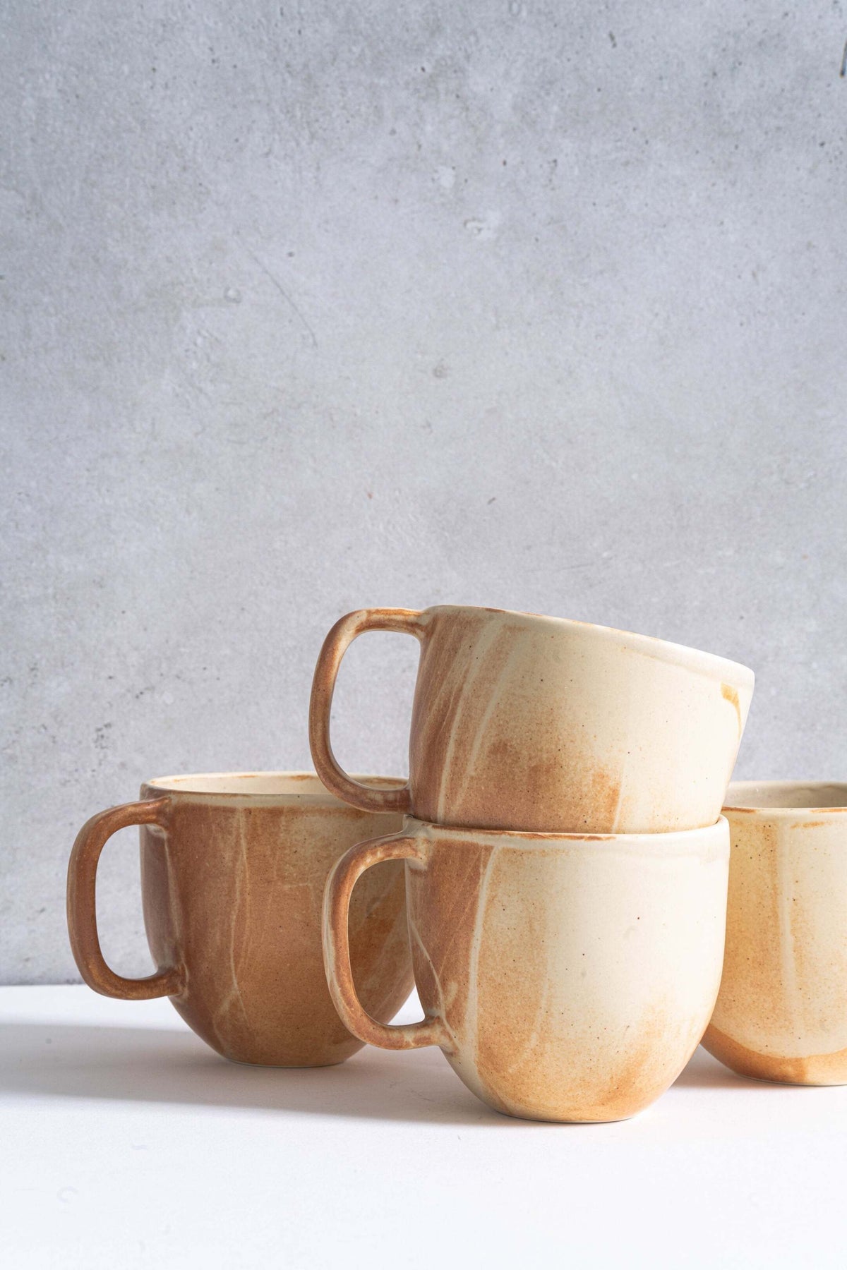 Stoneware beige coffee mug with handle and unique reactive glaze swirl