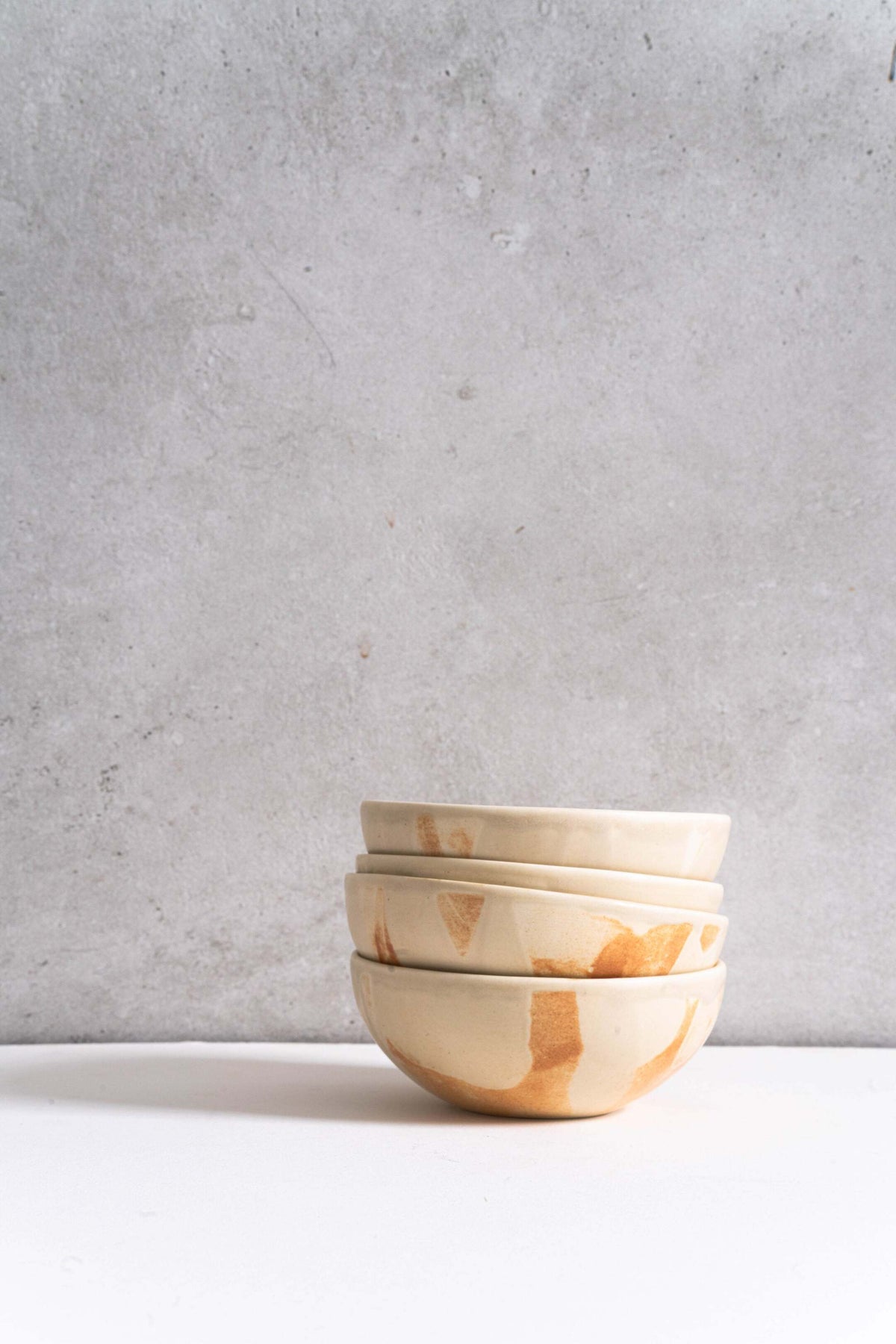 Beige matte stoneware bowl with unique reactive glaze and rust color strokes handcrafted in Ukraine