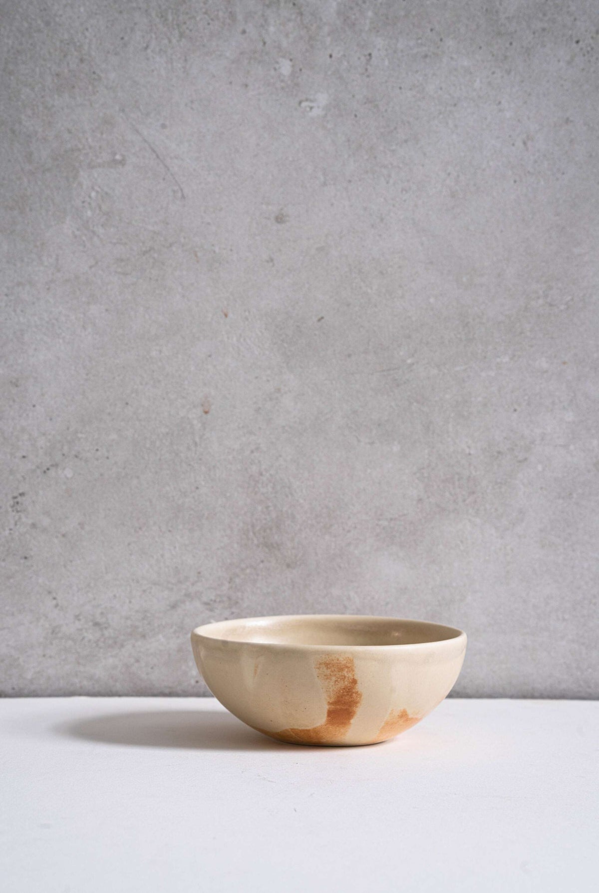 Beige matte stoneware bowl with reactive glaze and rust color strokes, handmade in Ukraine