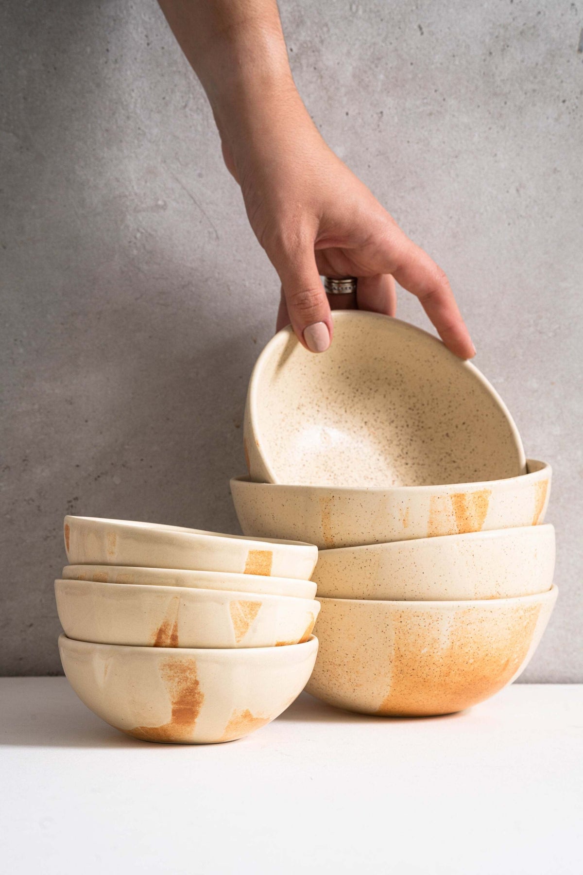Beige matte stoneware bowl with unique rust glaze strokes, handmade and dishwasher safe