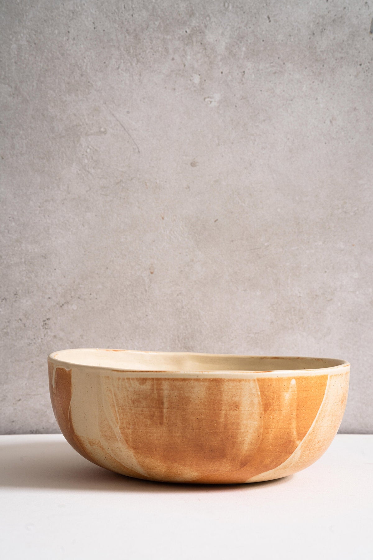 Beige matte stoneware salad serving bowl with unique rust color glaze strokes, handmade in Ukraine