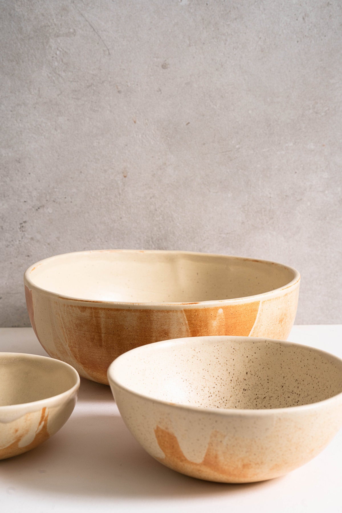 Beige matte stoneware salad serving bowl with unique reactive glaze and rust color strokes