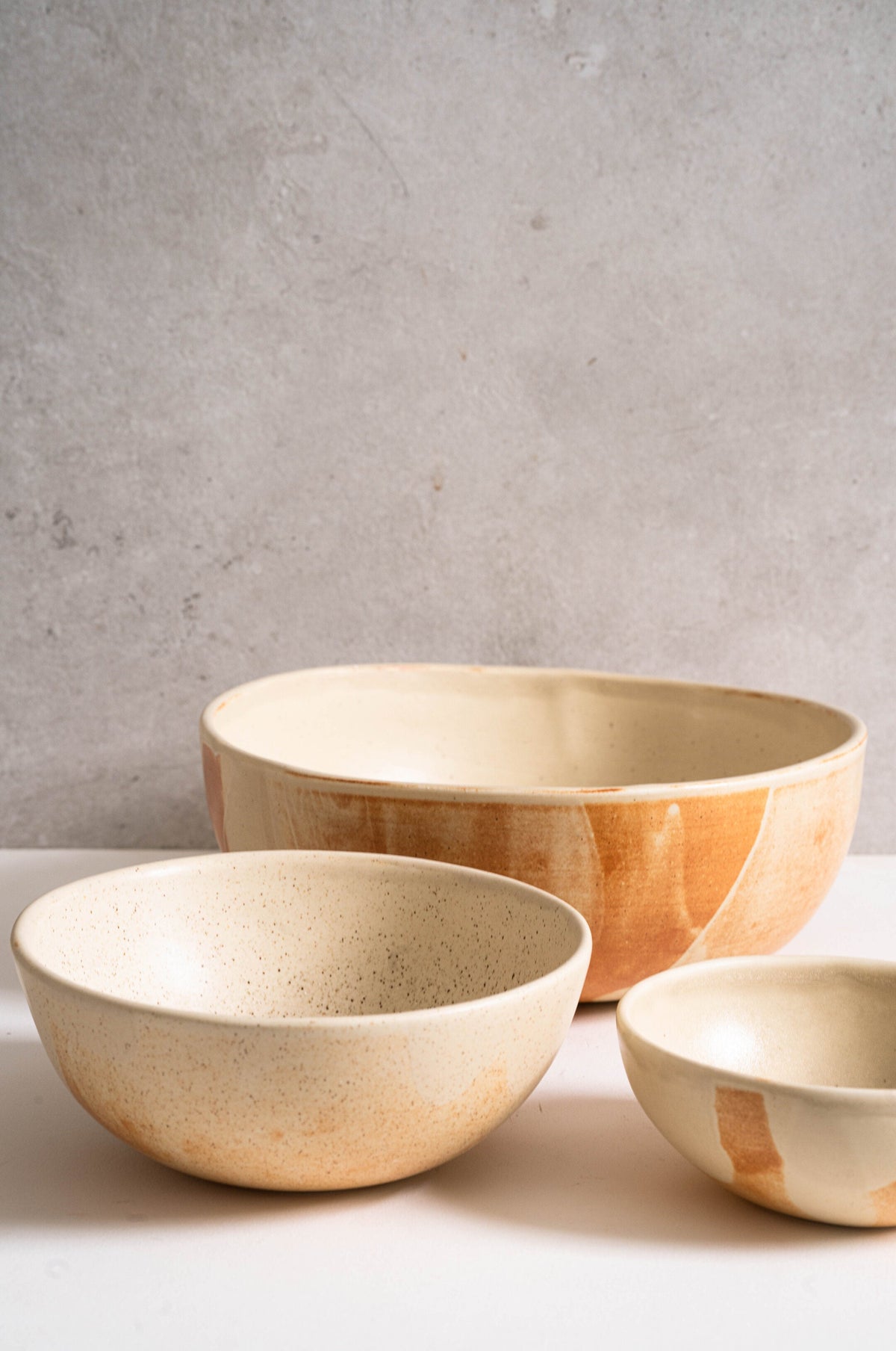 Beige matte stoneware salad serving bowl with unique reactive glaze and rust-colored strokes, handmade in Ukraine