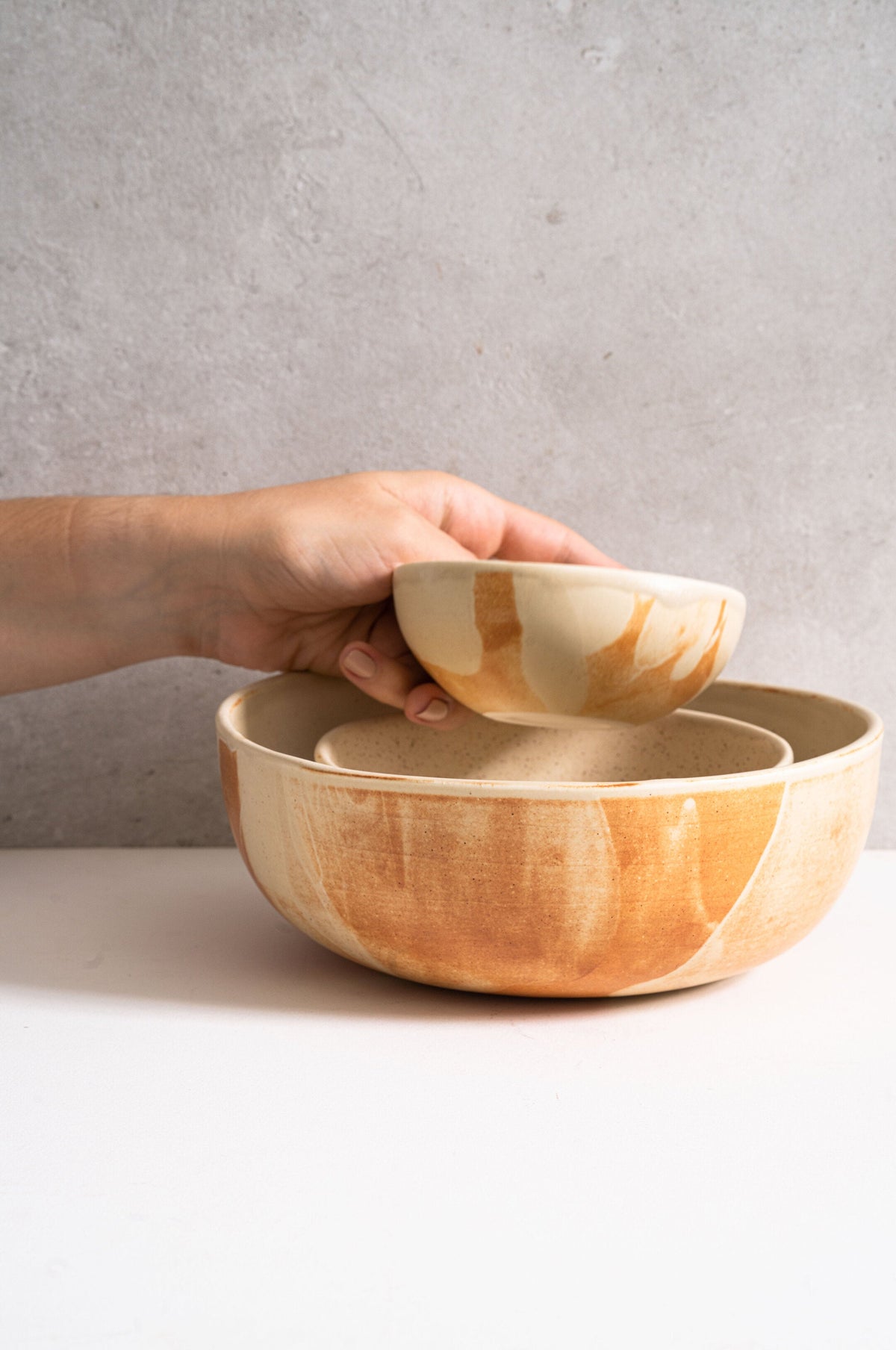 Beige matte stoneware salad serving bowl with unique reactive glaze and rust color strokes, handmade in Ukraine