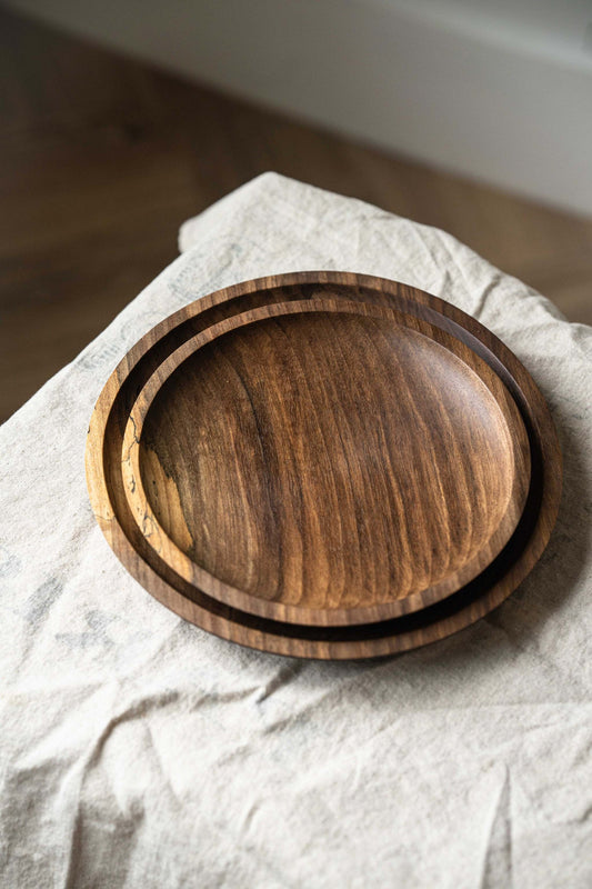 Hand carved wooden walnut plate set with unique wood grain and curved rim