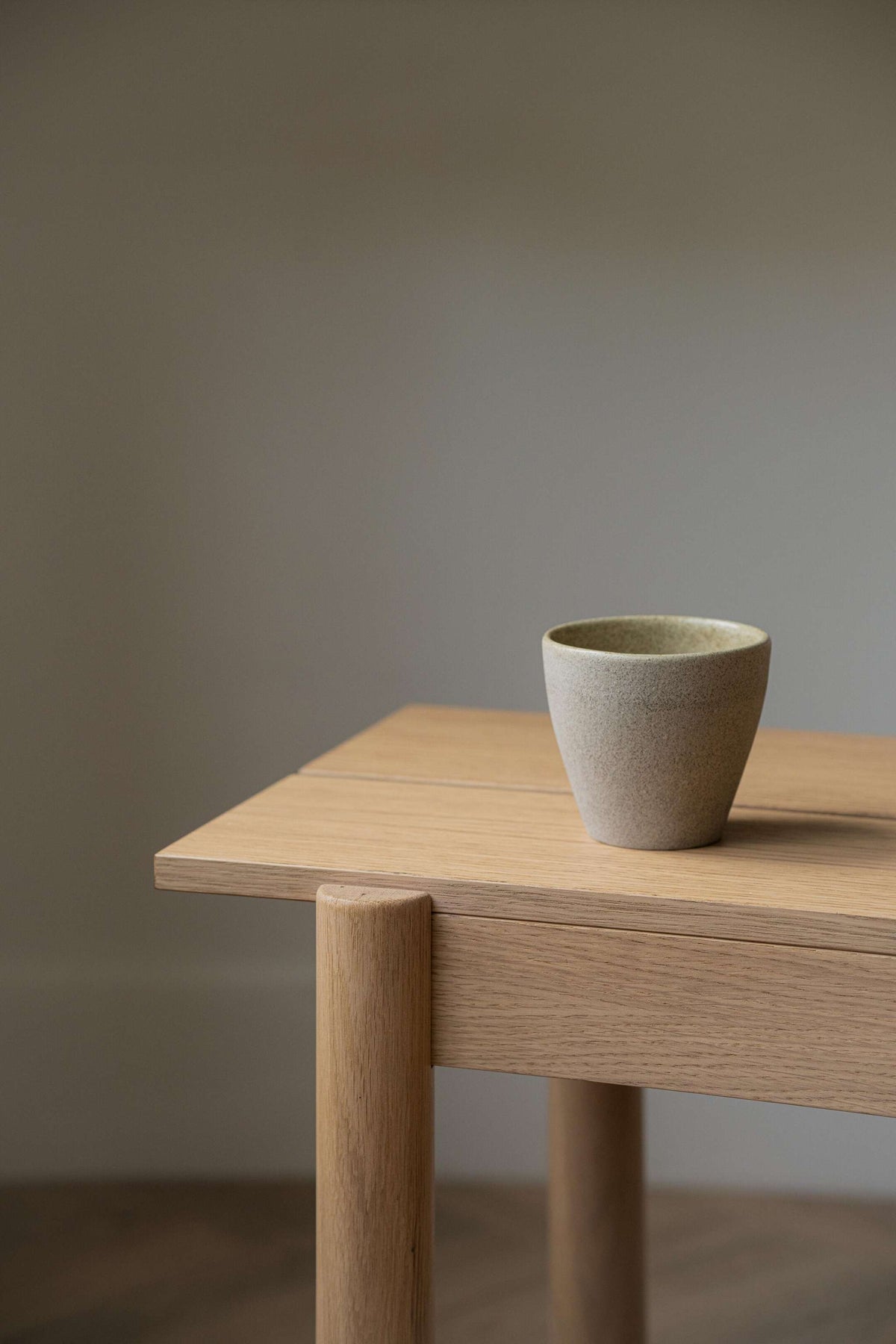 Handmade stoneware coffee mug with concrete-like texture and glossy interior glaze