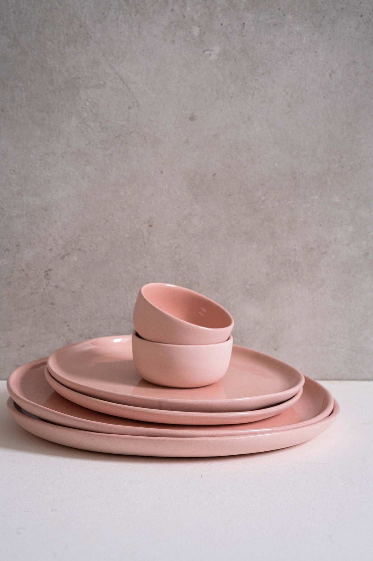 Set of handmade porcelain dinner plates in powder pink with shiny glazed interior and smooth polished exterior