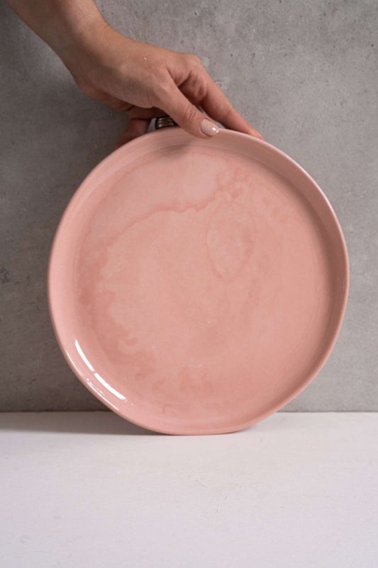 Set of handmade porcelain dinner plates in powder pink with shiny glazed interior and polished exterior