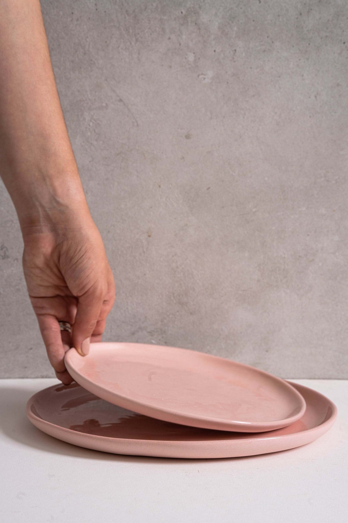 Handmade porcelain dinner plates set in powder pink with shiny glazed interior and smooth polished exterior