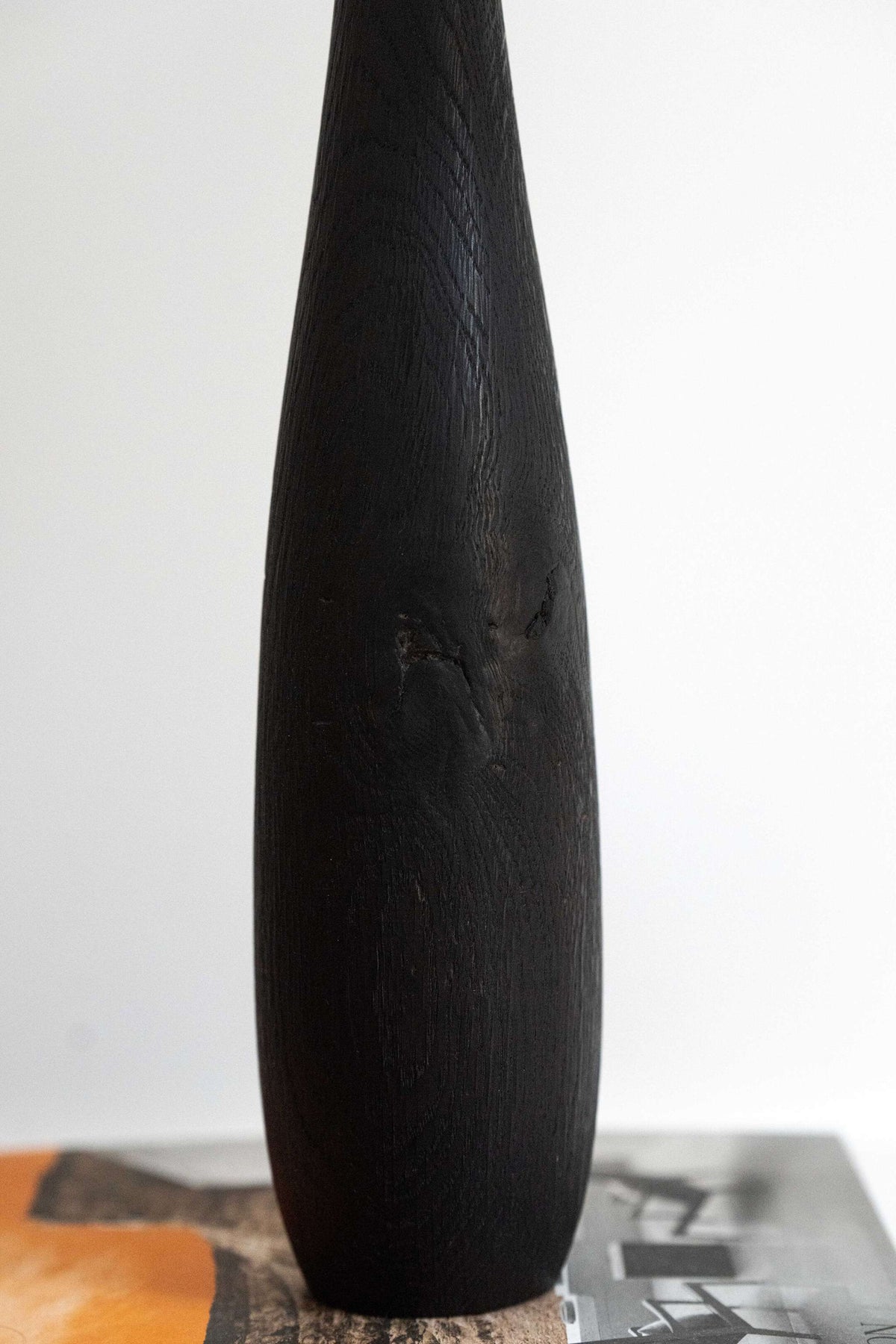 Tall charred oak wood vase with sharp shoulders and long neck, handcarved with natural wood texture.