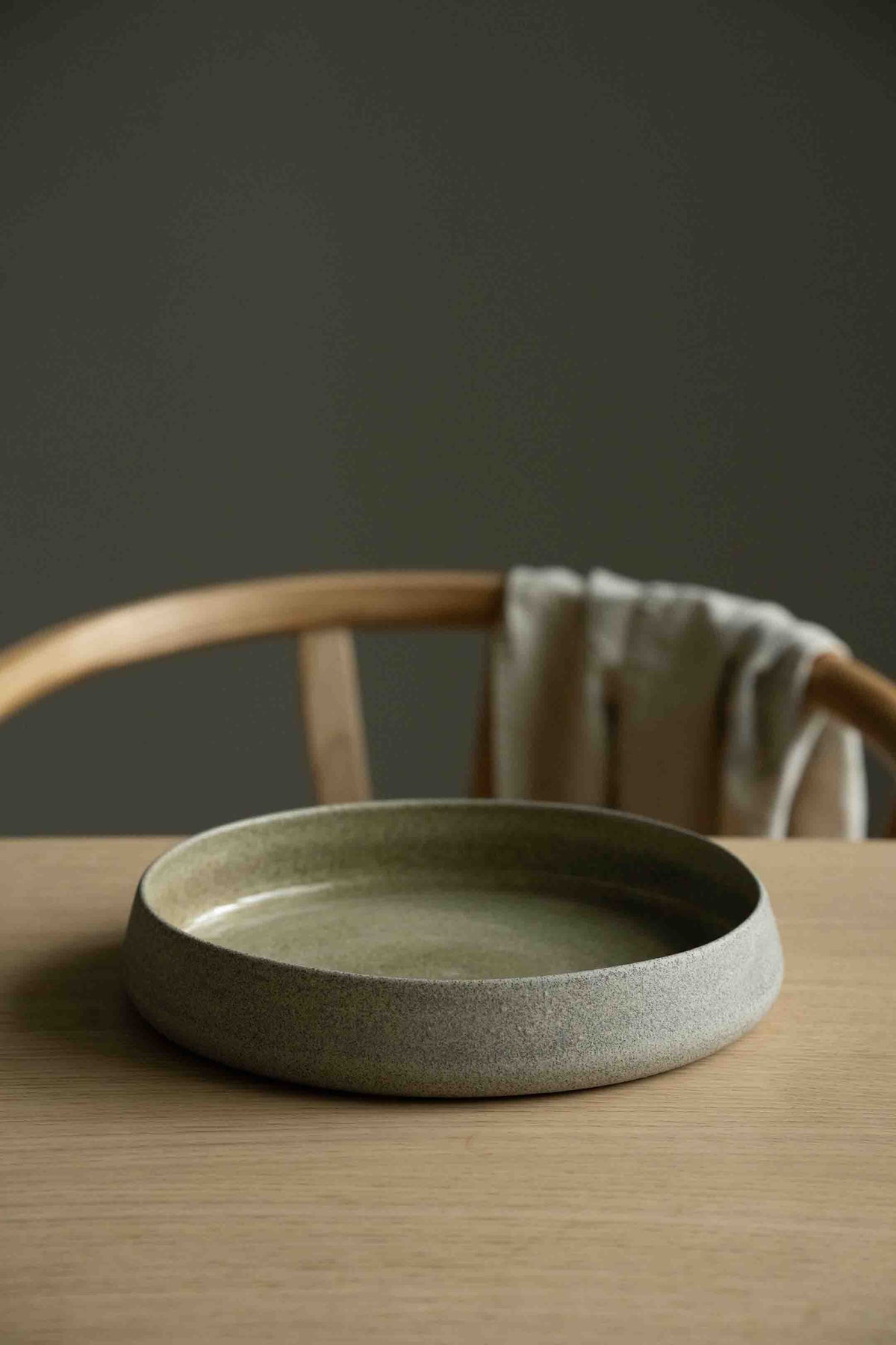 Handmade stoneware dinner set from the Concrete Collection with dinner plate, salad plate, bowl, and coffee cup featuring a rough matte exterior and glossy glazed interior.