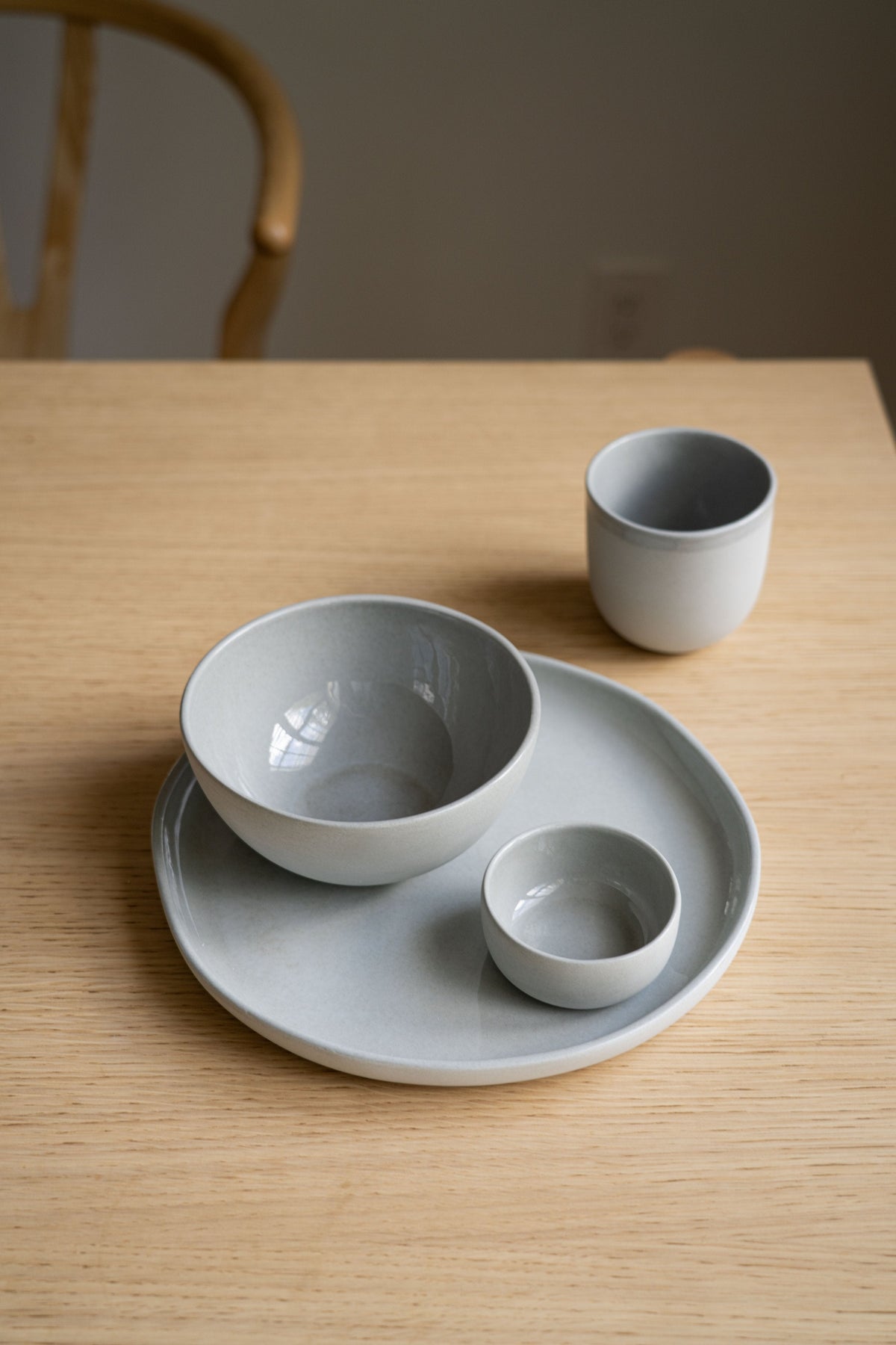 Handmade porcelain bowl in gray sky color with shiny food-safe glaze, polished exterior, and smooth finish