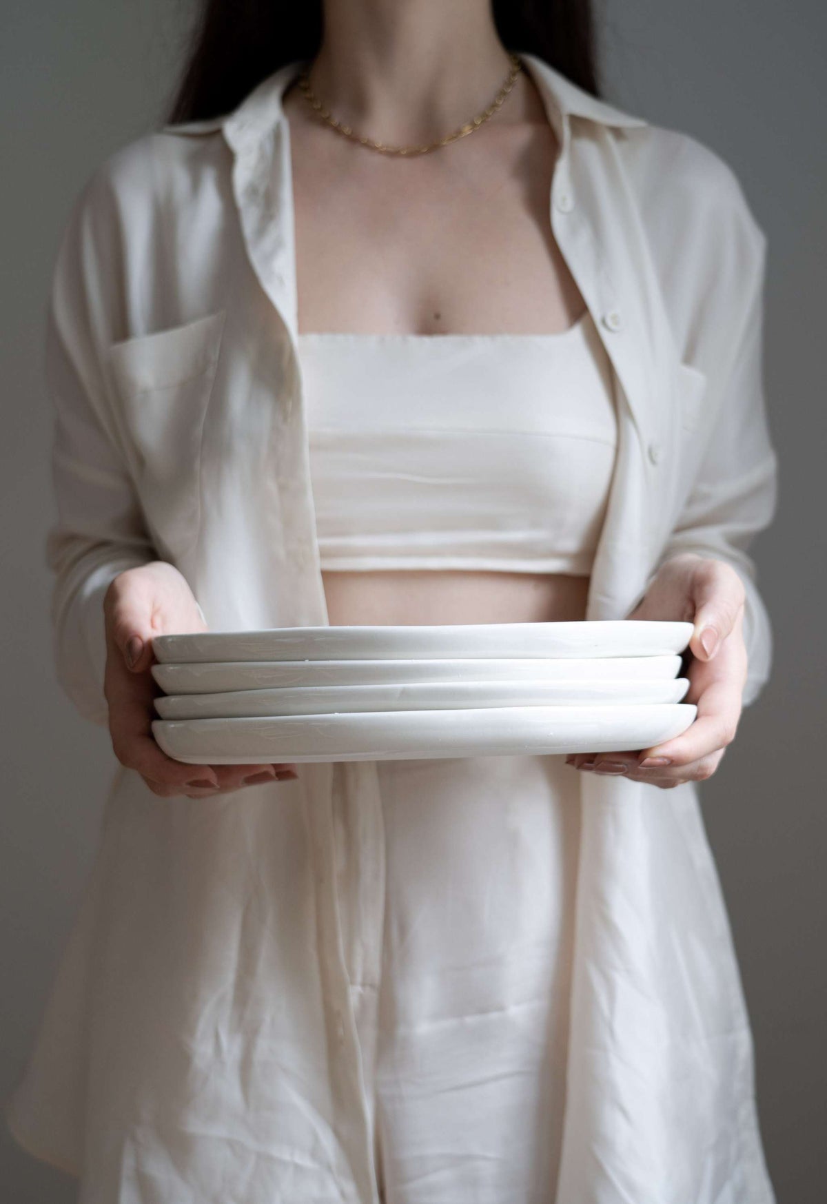 Handmade off-white porcelain dinner plates with hand-painted strokes, shiny glaze, and simple elegant design
