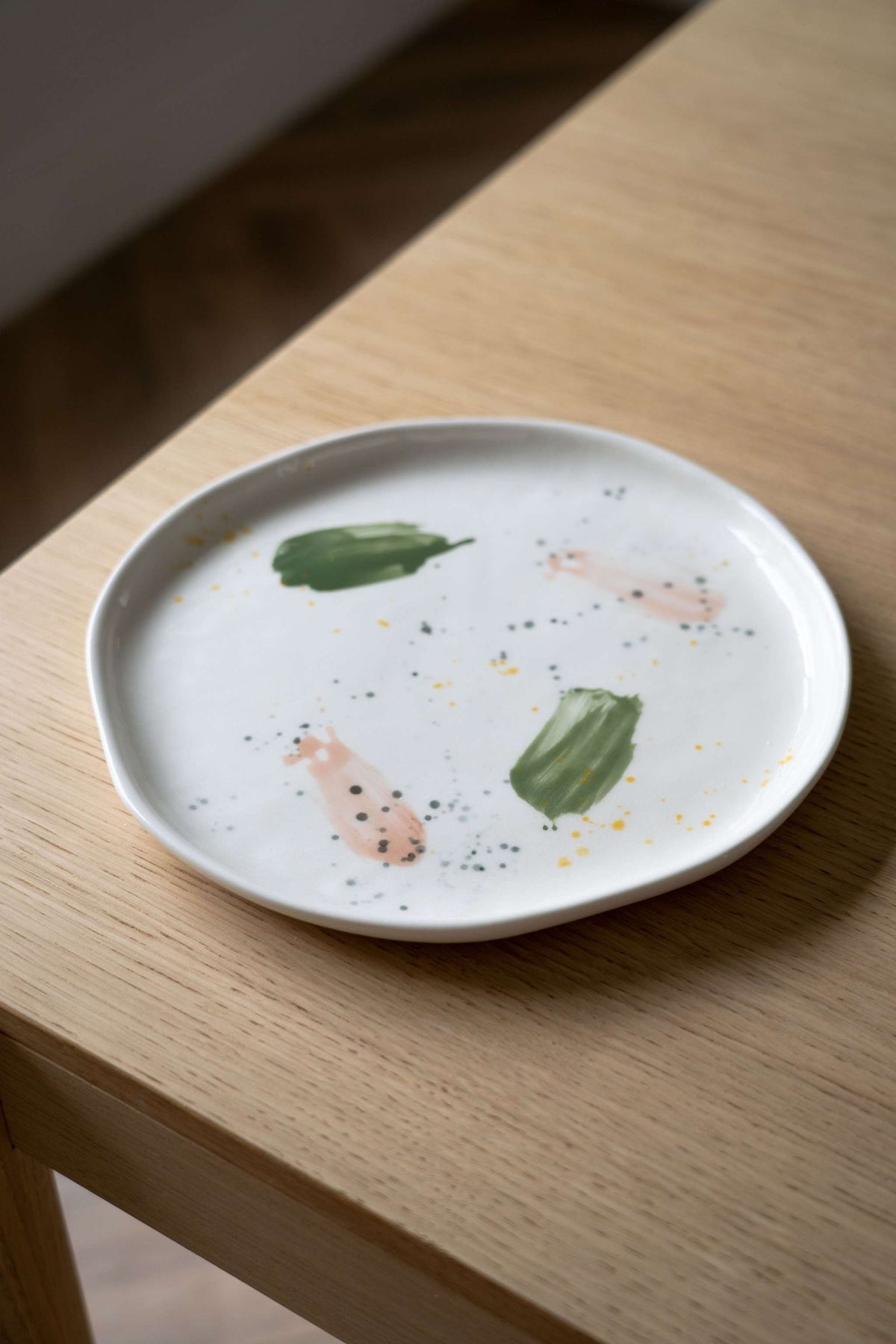 Off-white handmade porcelain dinner plate with hand-painted strokes and shiny glaze