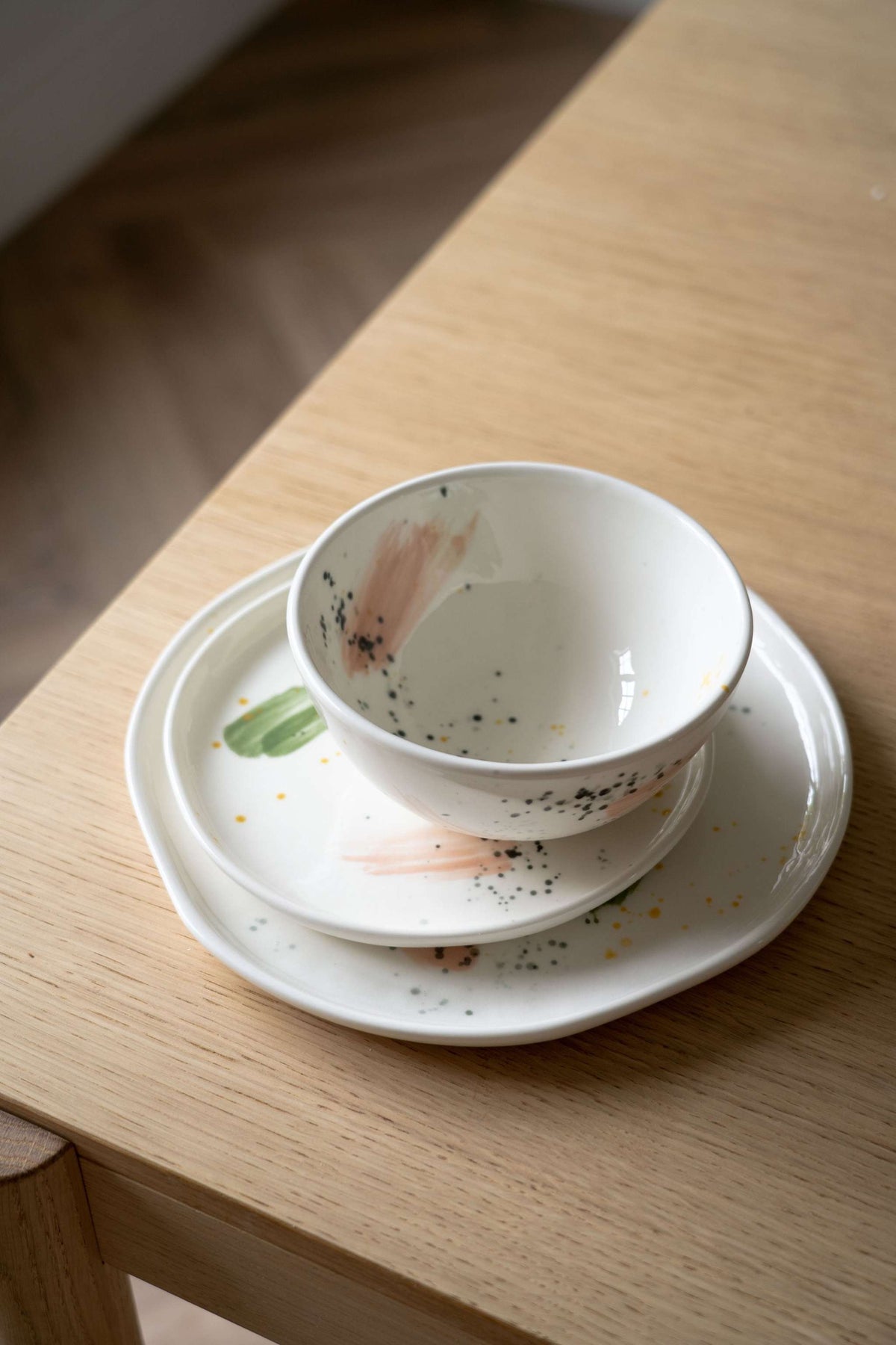 Off-white handmade porcelain dinner plate with hand-painted strokes, shiny glaze, and simple elegant design
