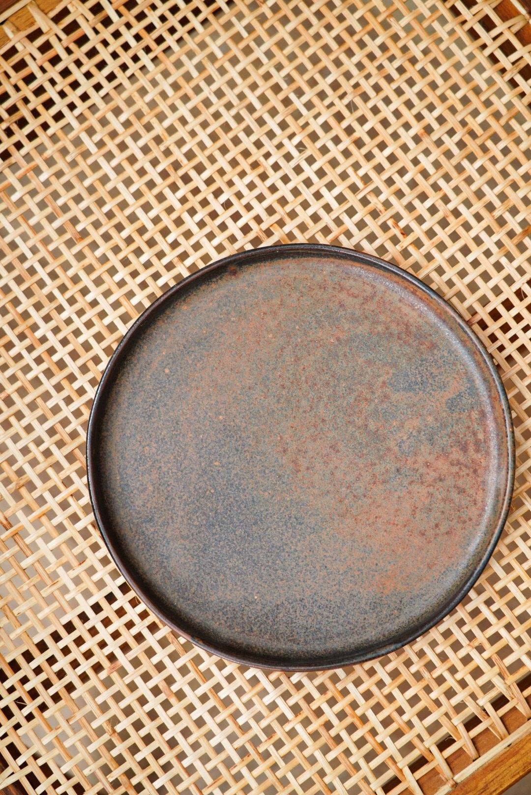 Matte brown-black rust stoneware dinner plate with reactive glaze swirl, handmade in Ukraine