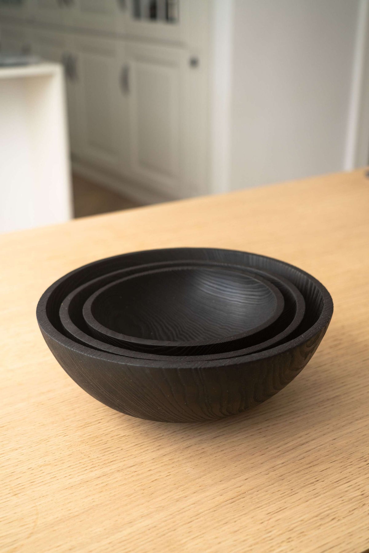 Hand Carved Charred Wooden Salad Bowl Set in black wood, featuring three nested bowls with smooth carved interiors and natural grain.