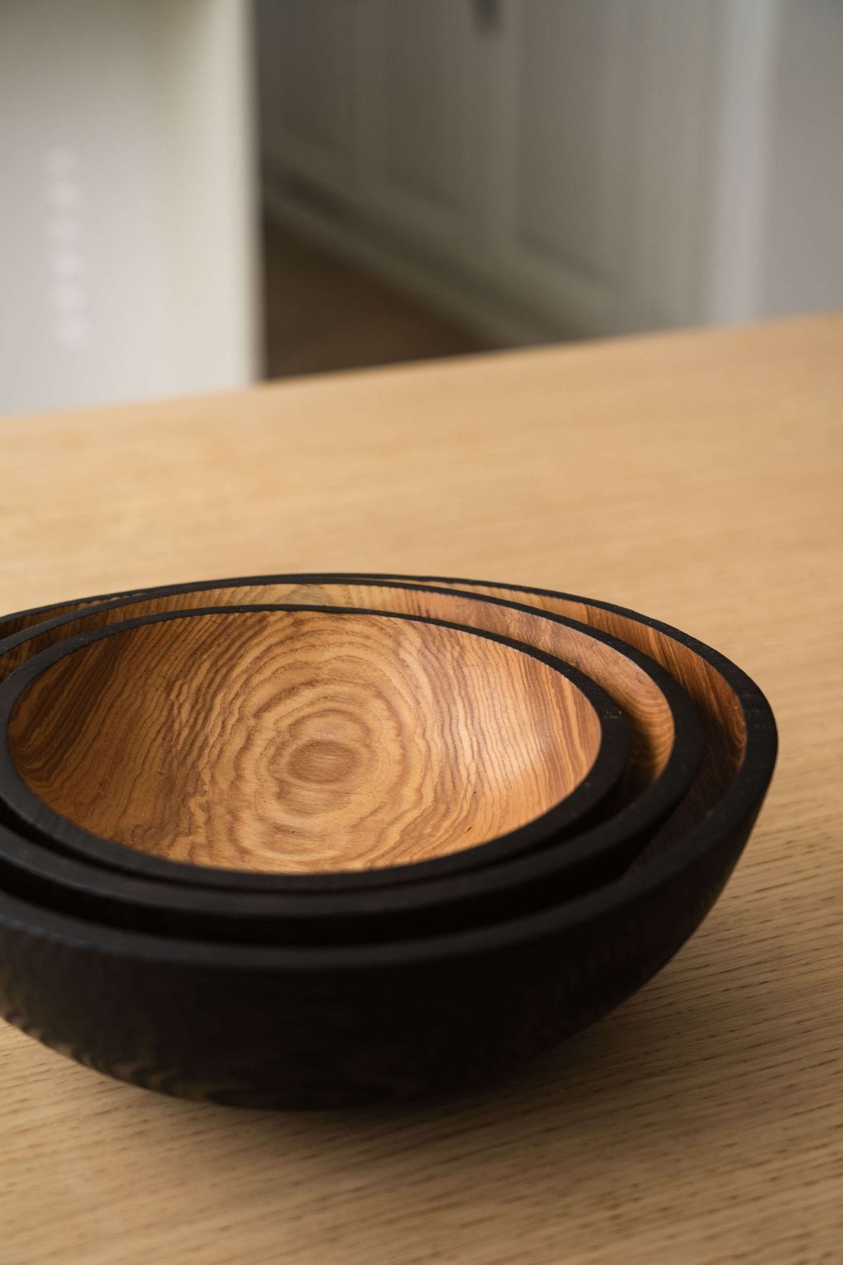 Nesting Bowl Set of three hand-carved ashwood bowls, with natural swirling grain inside and charred black exteriors.