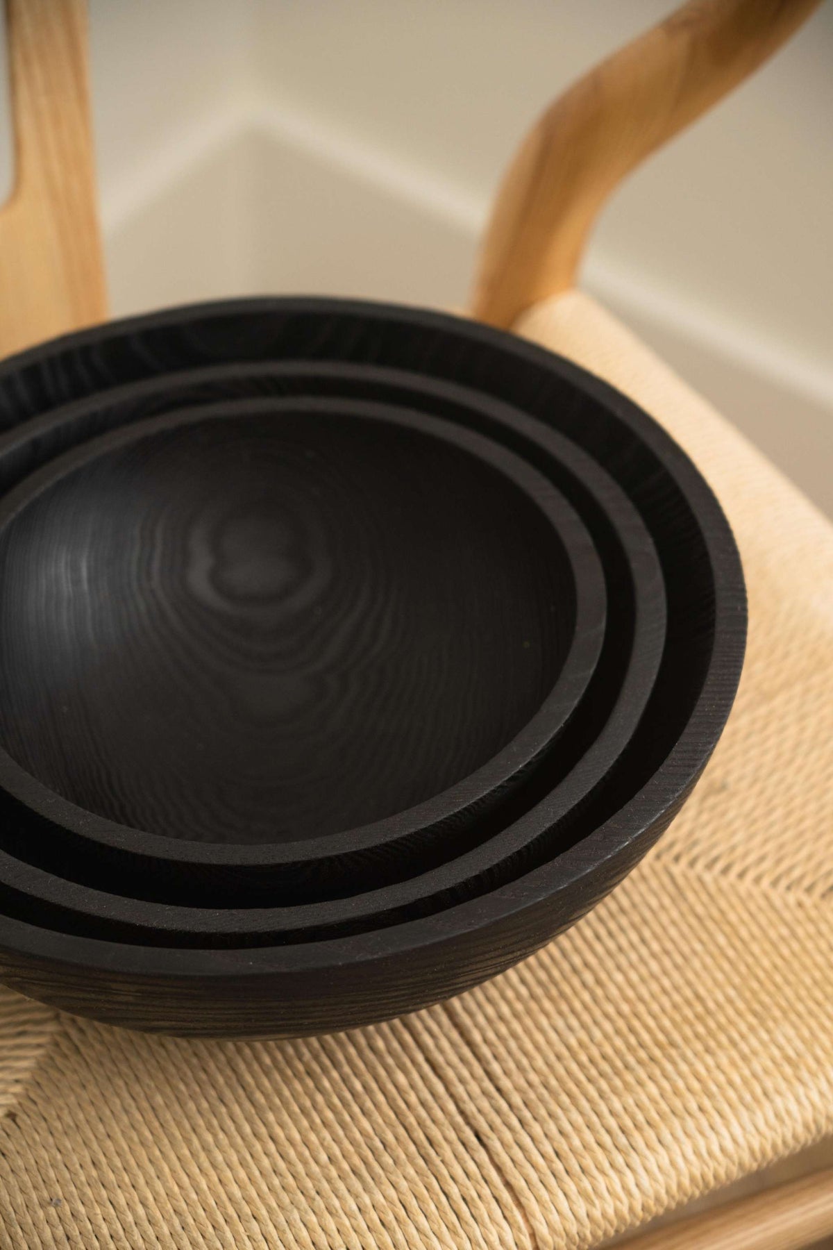Hand Carved Charred Wooden Salad Bowl Set in black wood, featuring nested bowls with smooth interiors and carved rims.