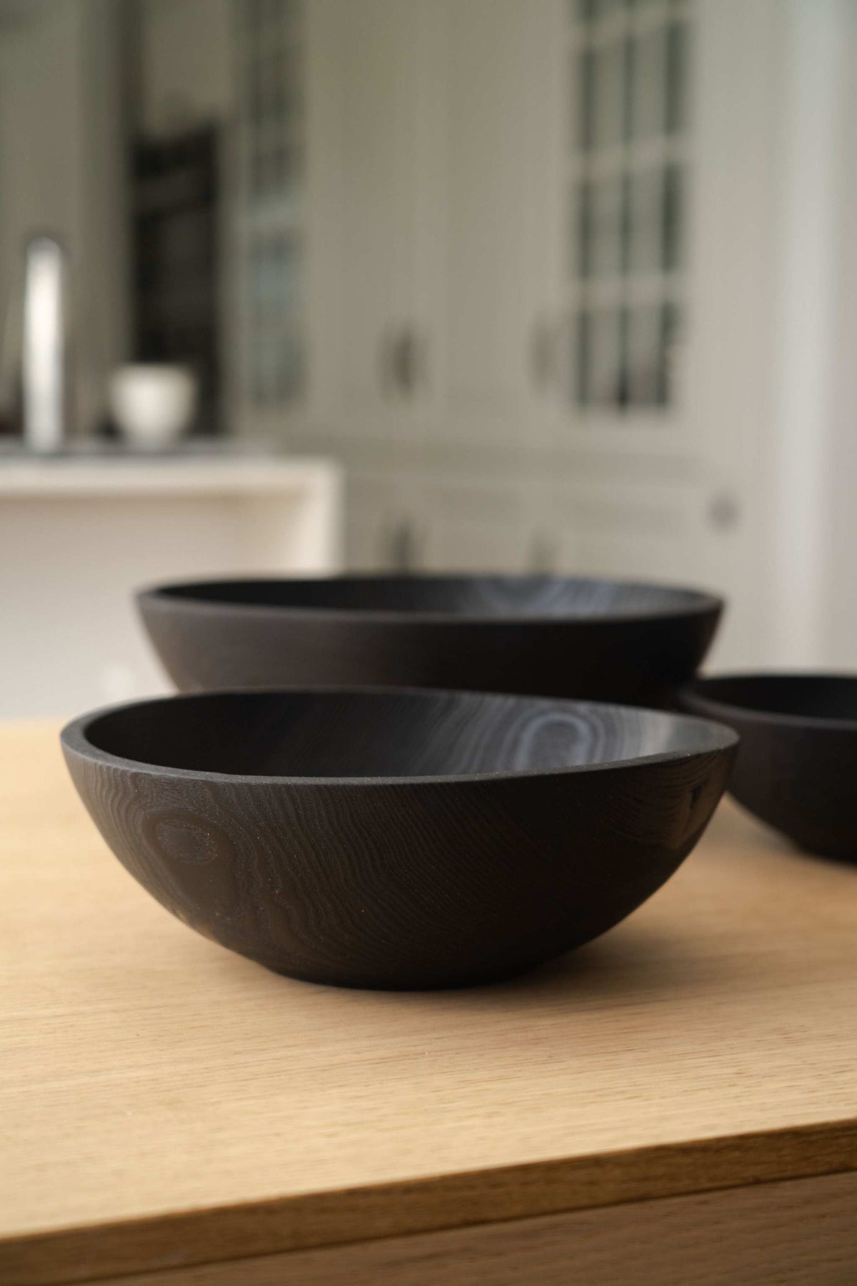 Hand Carved Charred Wooden Salad Bowl Set in deep black wood, featuring smooth rounded bowls with visible carved grain.