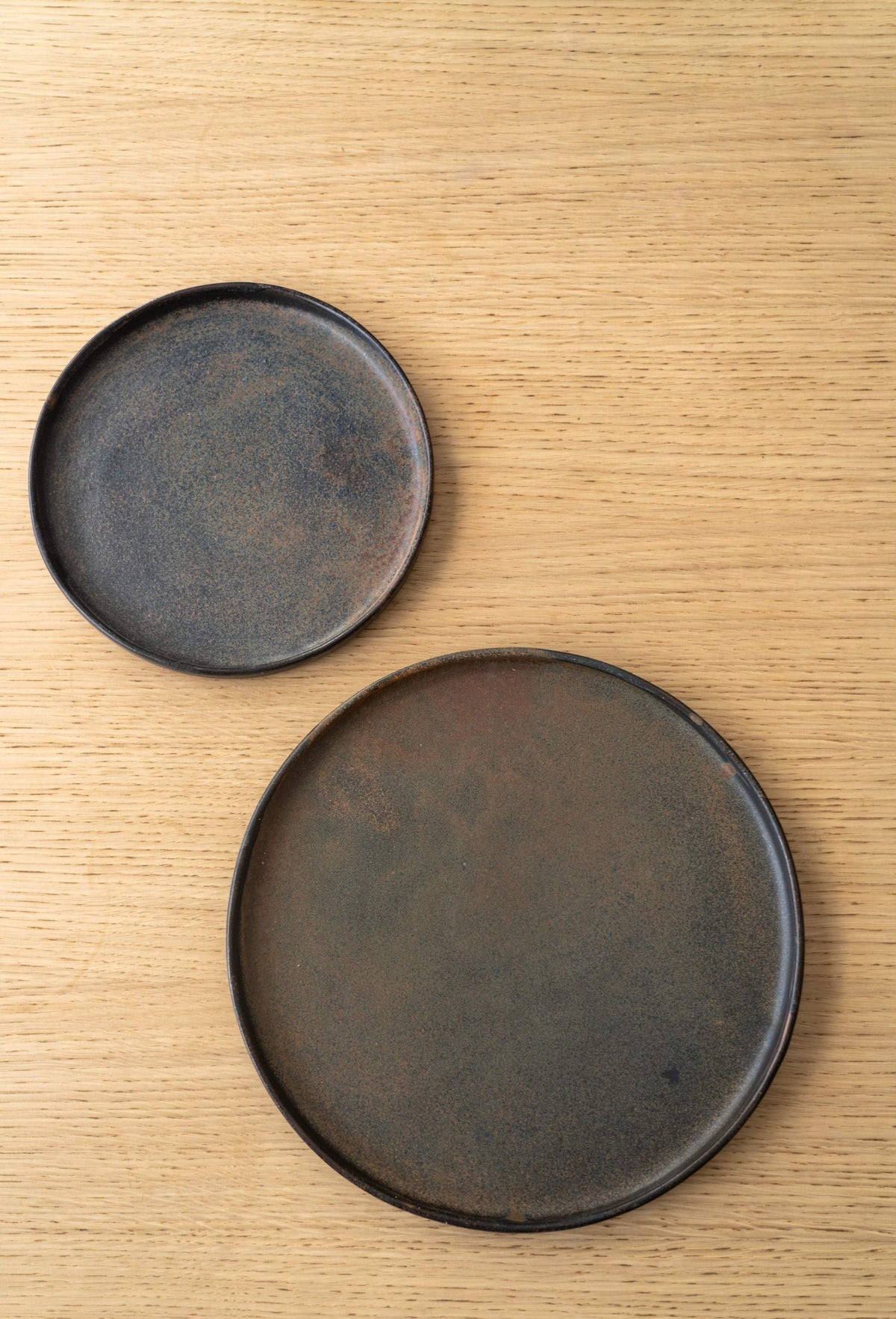 Matte rust stoneware dinner plate with reactive glaze swirl, handmade in Ukraine