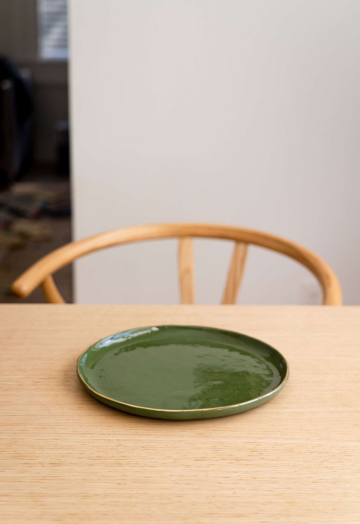 Handmade porcelain dinner plate with gold rim and green background