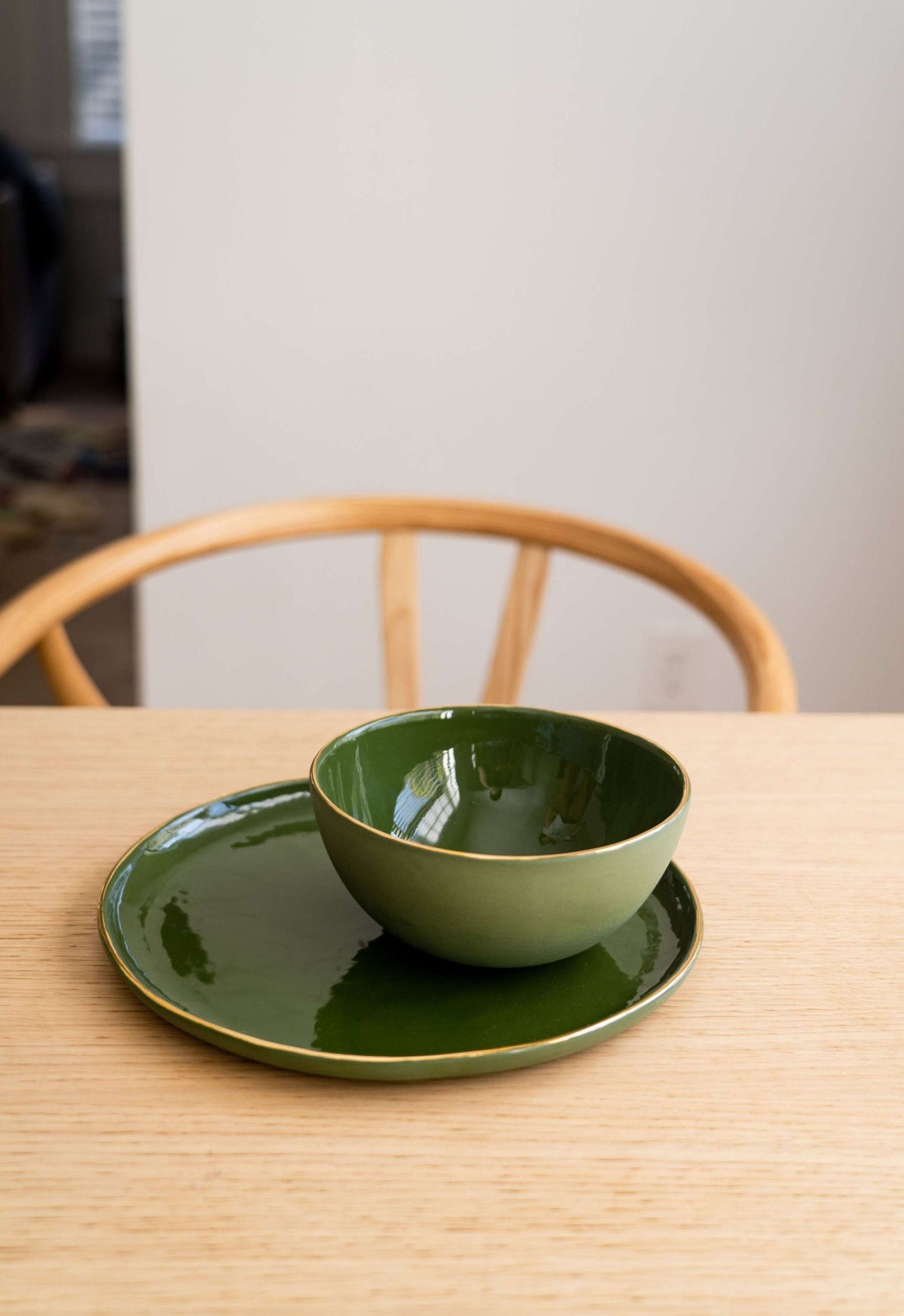 Handmade porcelain dinner plate with gold rim and green background