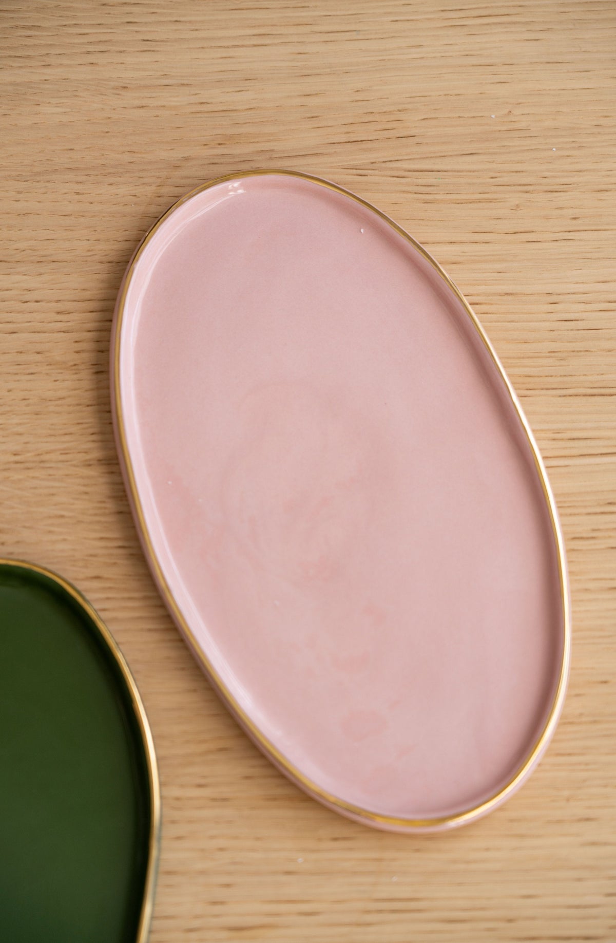 Handmade oval porcelain serving platter in powder pink with gold rim