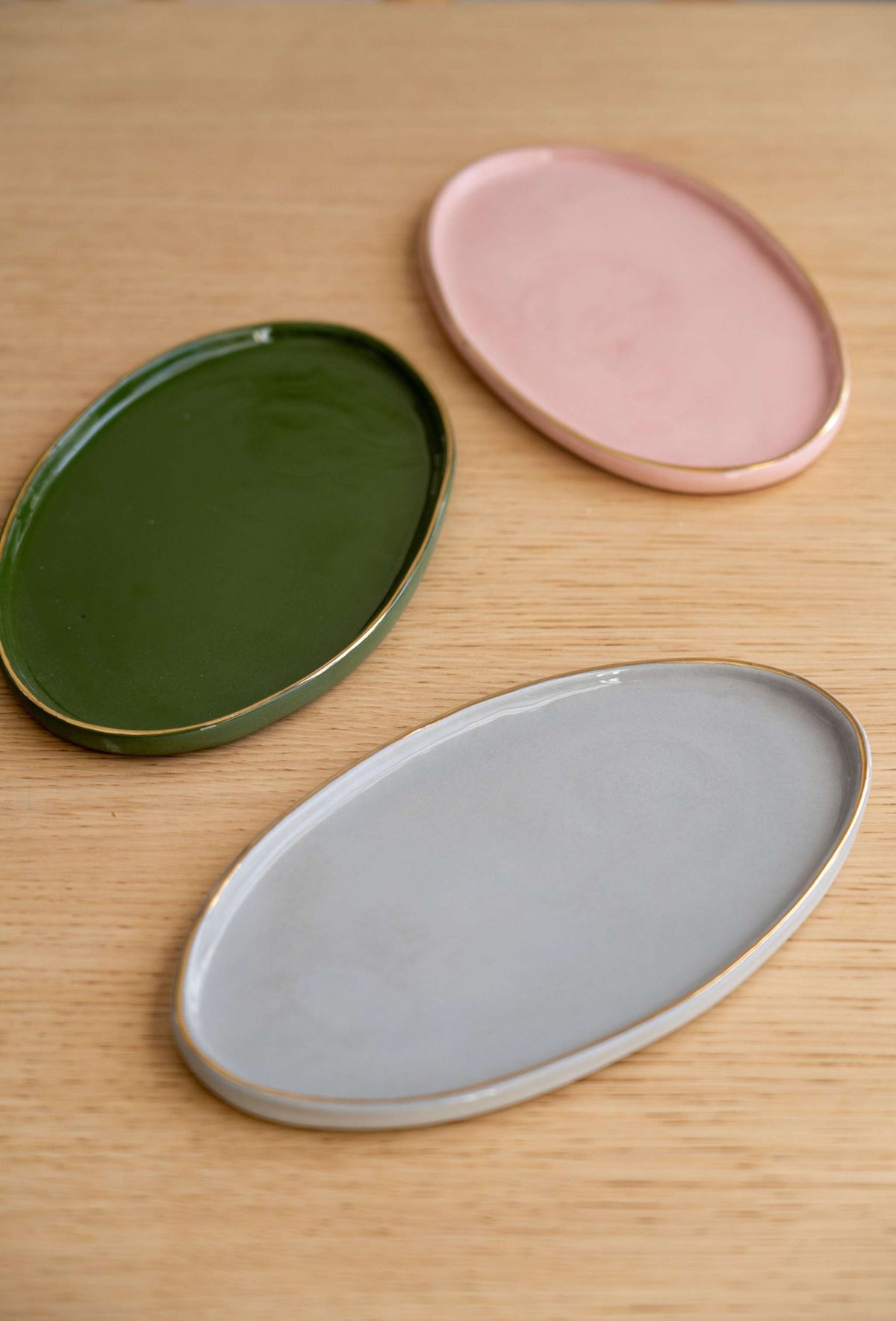Handmade oval porcelain serving platter in powder pink with gold rim