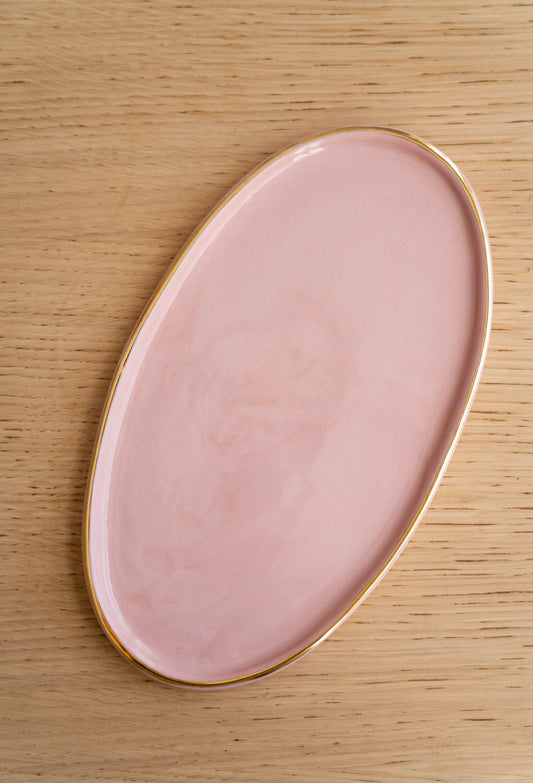 Handmade oval porcelain serving platter in powder pink with gold rim