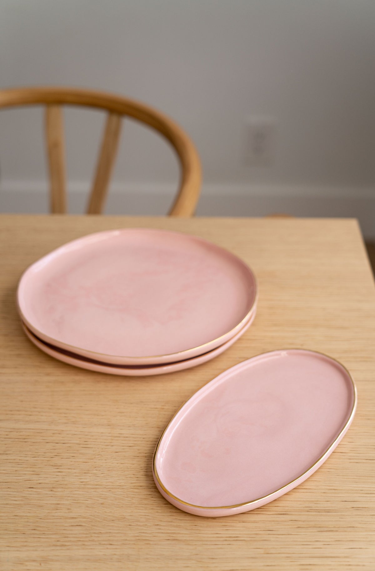 Handmade oval porcelain serving platter in powder pink with gold rim and organic round edges