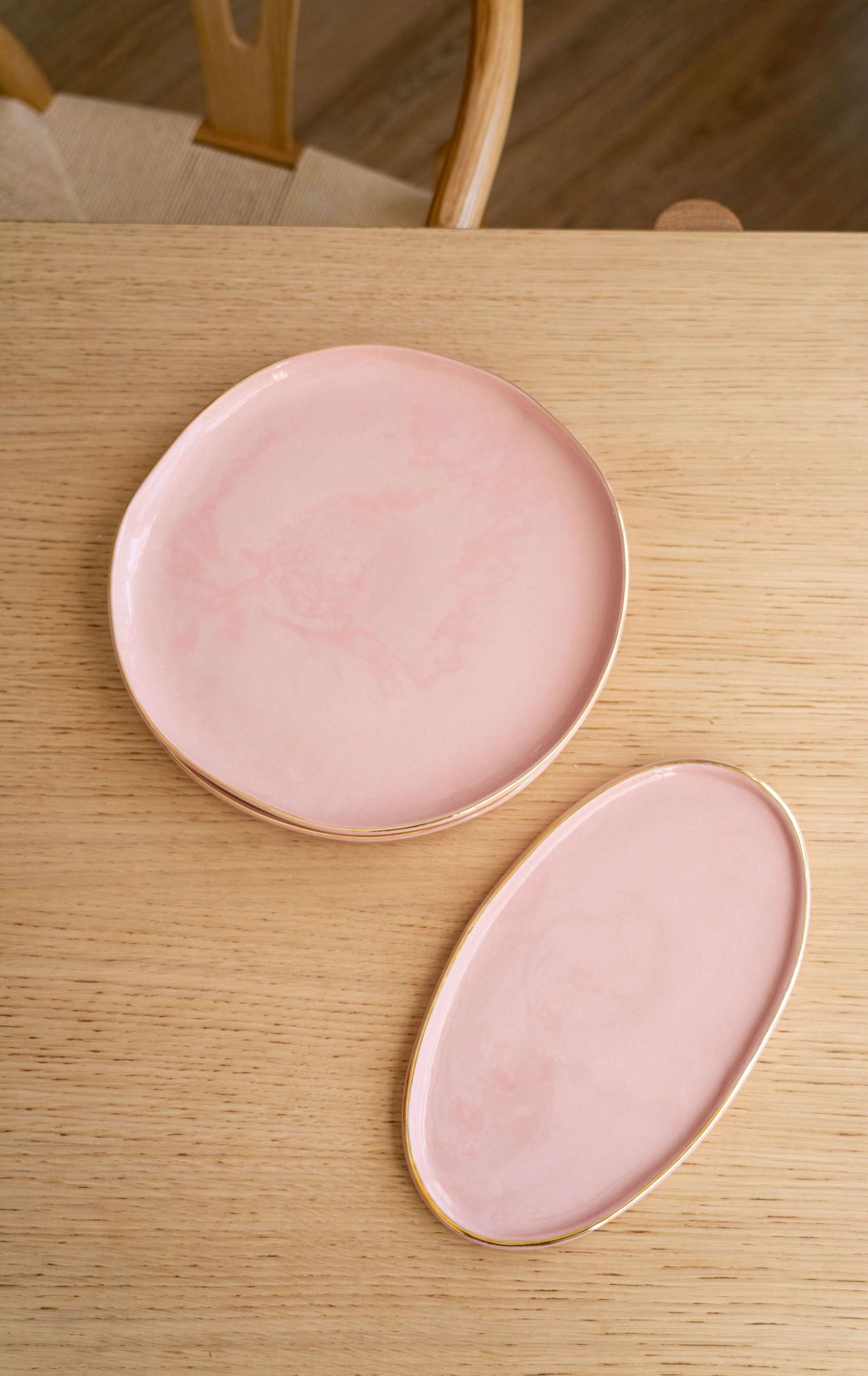 Handmade oval porcelain serving platter in powder pink with gold rim and organic edges