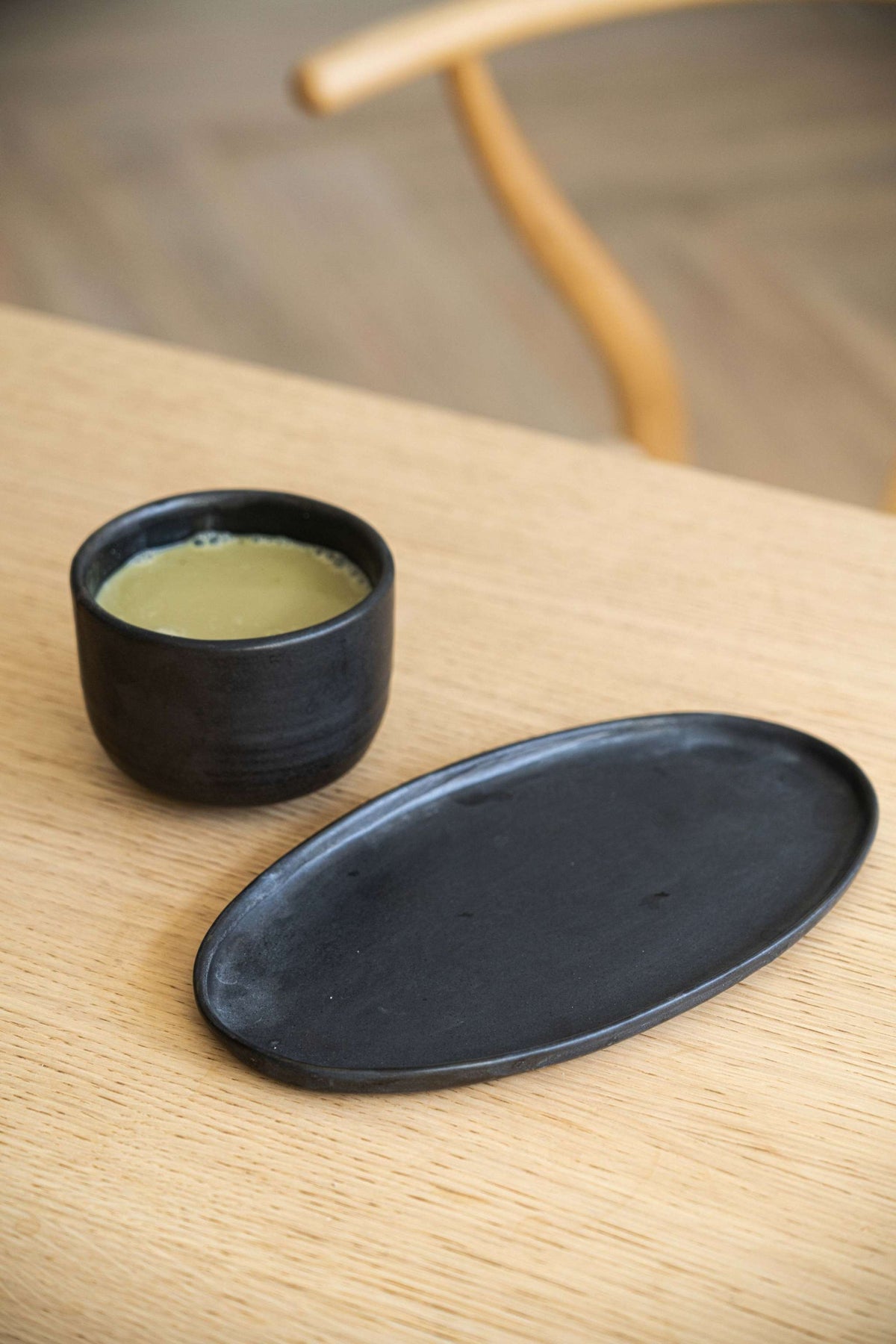 Black matte stoneware oval serving platter with organic edges and reactive glaze, handmade in Ukraine