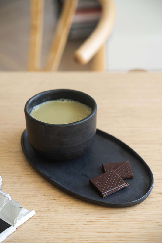 Handmade black matte stoneware oval serving platter with organic edges and reactive glaze, food-safe and lead-free.