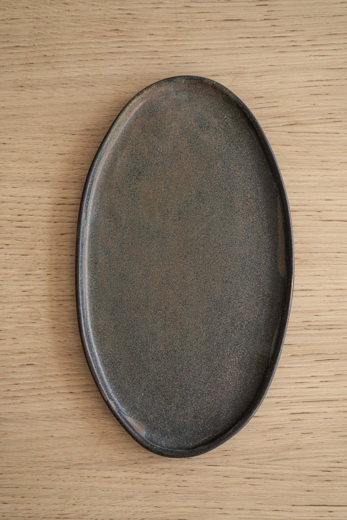 Rust matte stoneware serving platter with organic round edges and reactive glaze, handmade in Ukraine