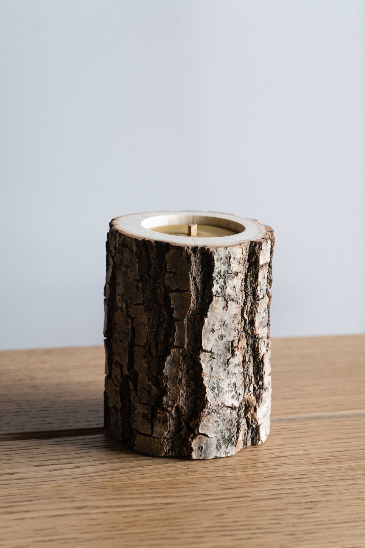 Rocky Wood Candle with multi-layer wick and Winter Spruce scent on wooden surface