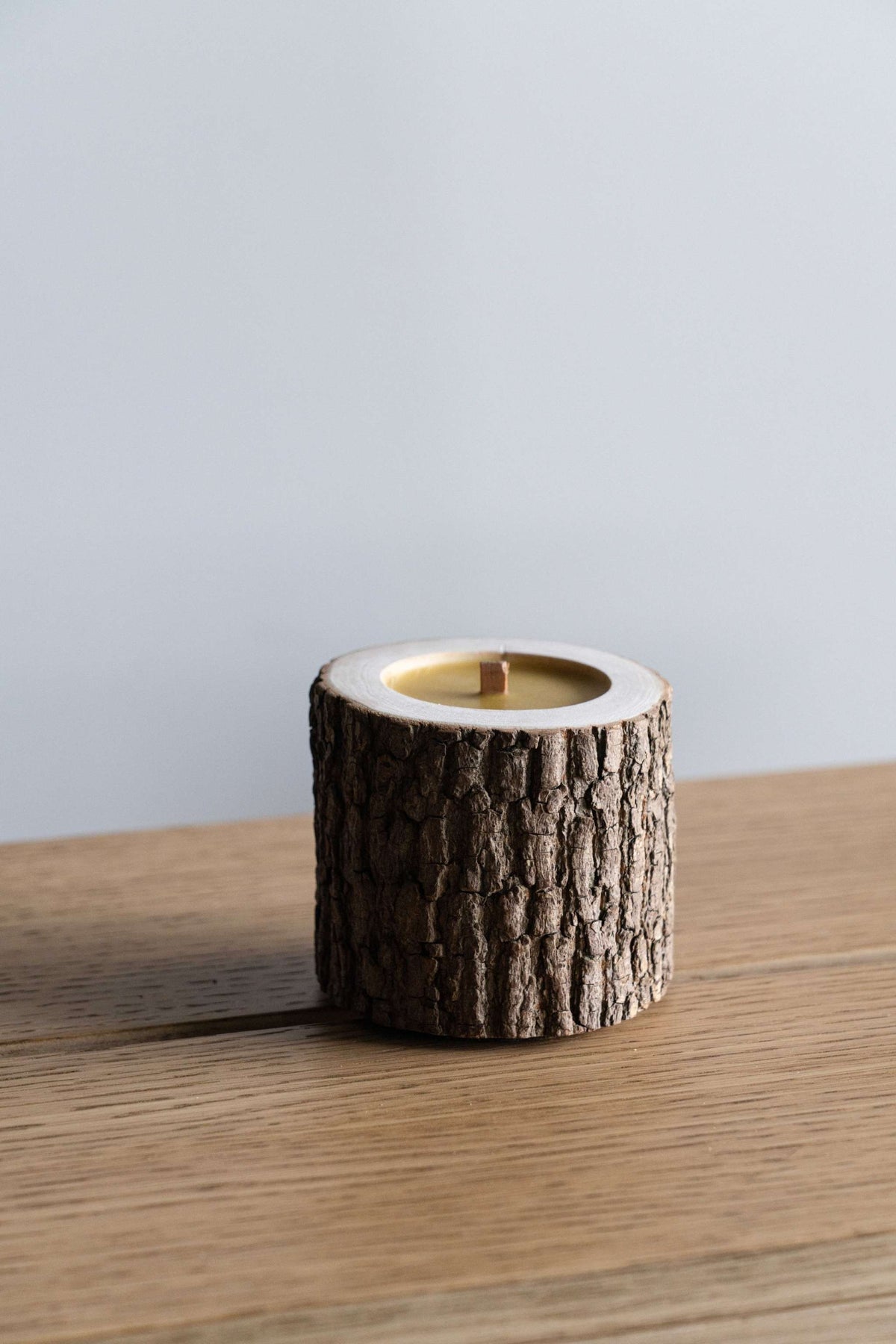 Rocky Wood Candle with multi-layer wick and Winter Spruce scent on wooden surface