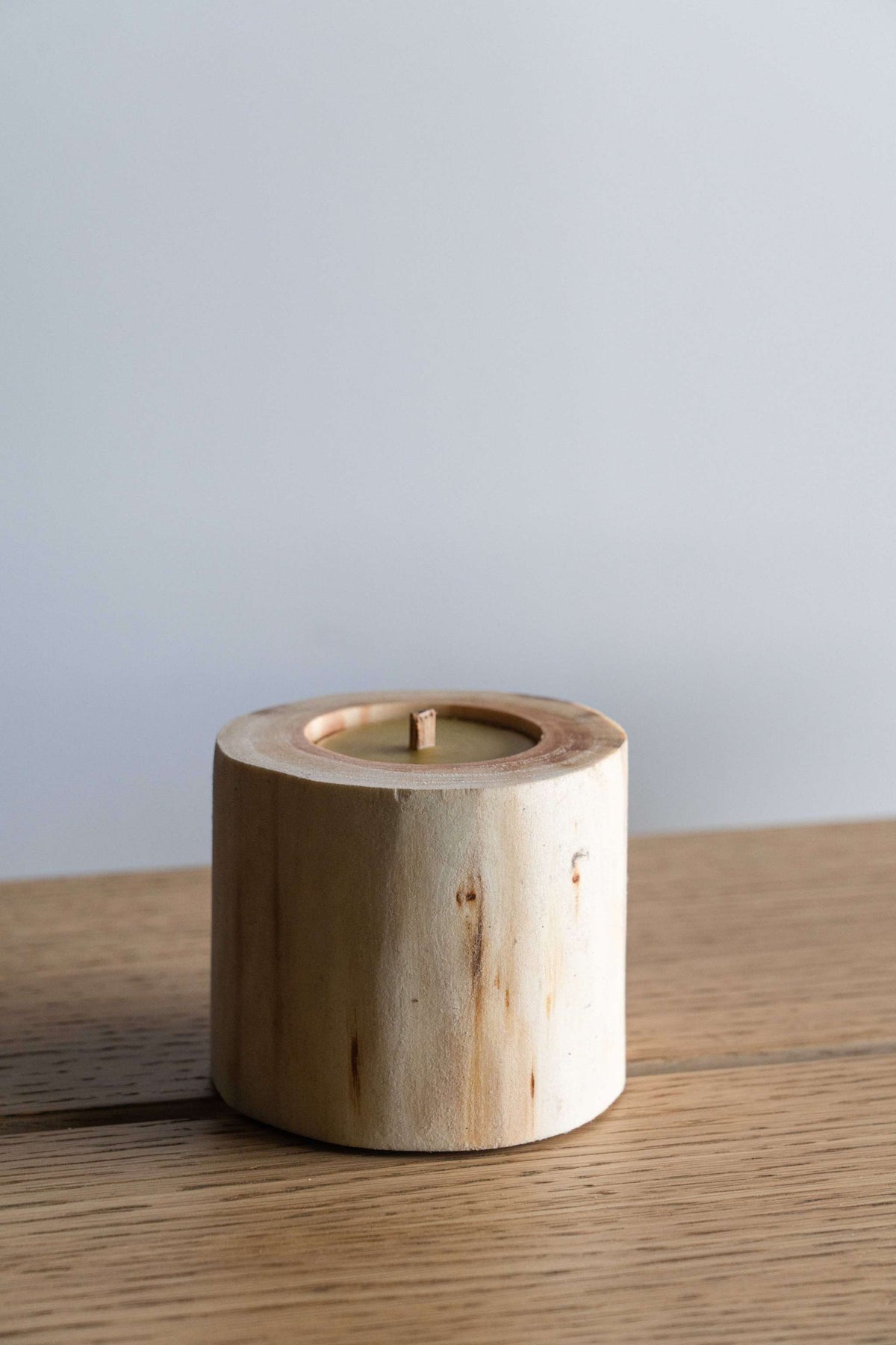 Hand Craft Ubud Wooden Candle, natural pale wood cylinder with visible grain, recessed wax center, and single wick.