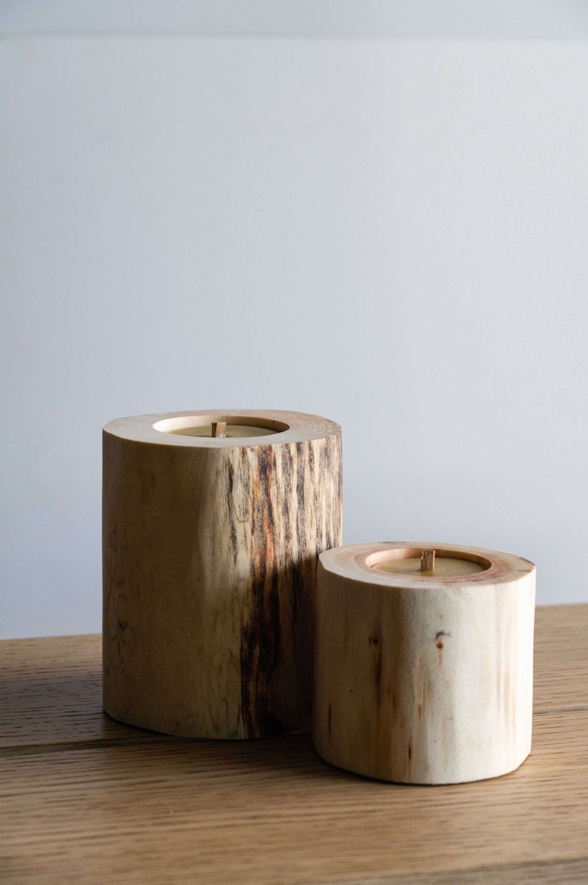 Hand Craft Ubud Wooden Candle, natural brown wood cylinders with visible grain, charred markings and recessed wax wicks.