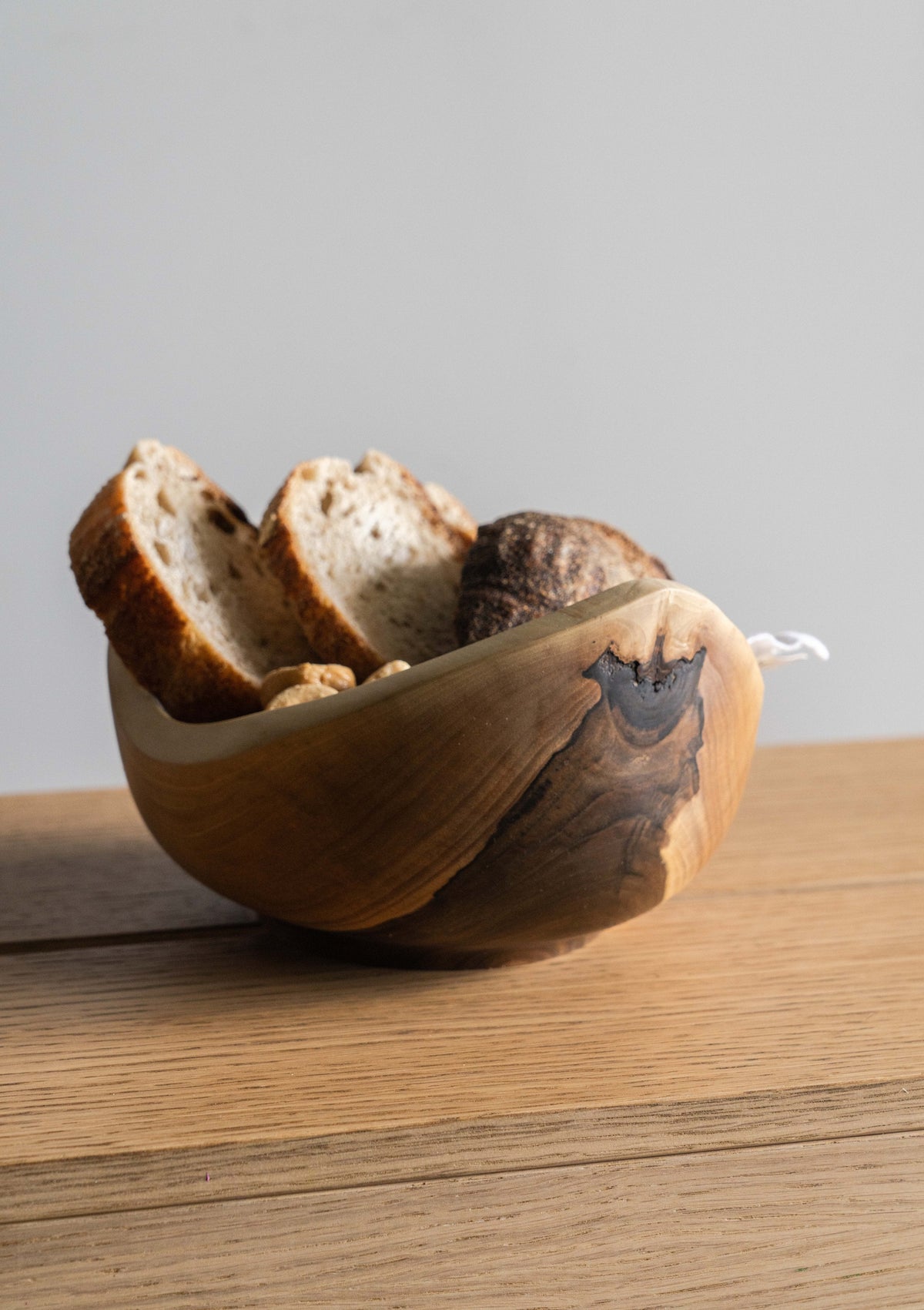 Hand carved small wooden walnut bowl with natural rings and oil finish on wooden table