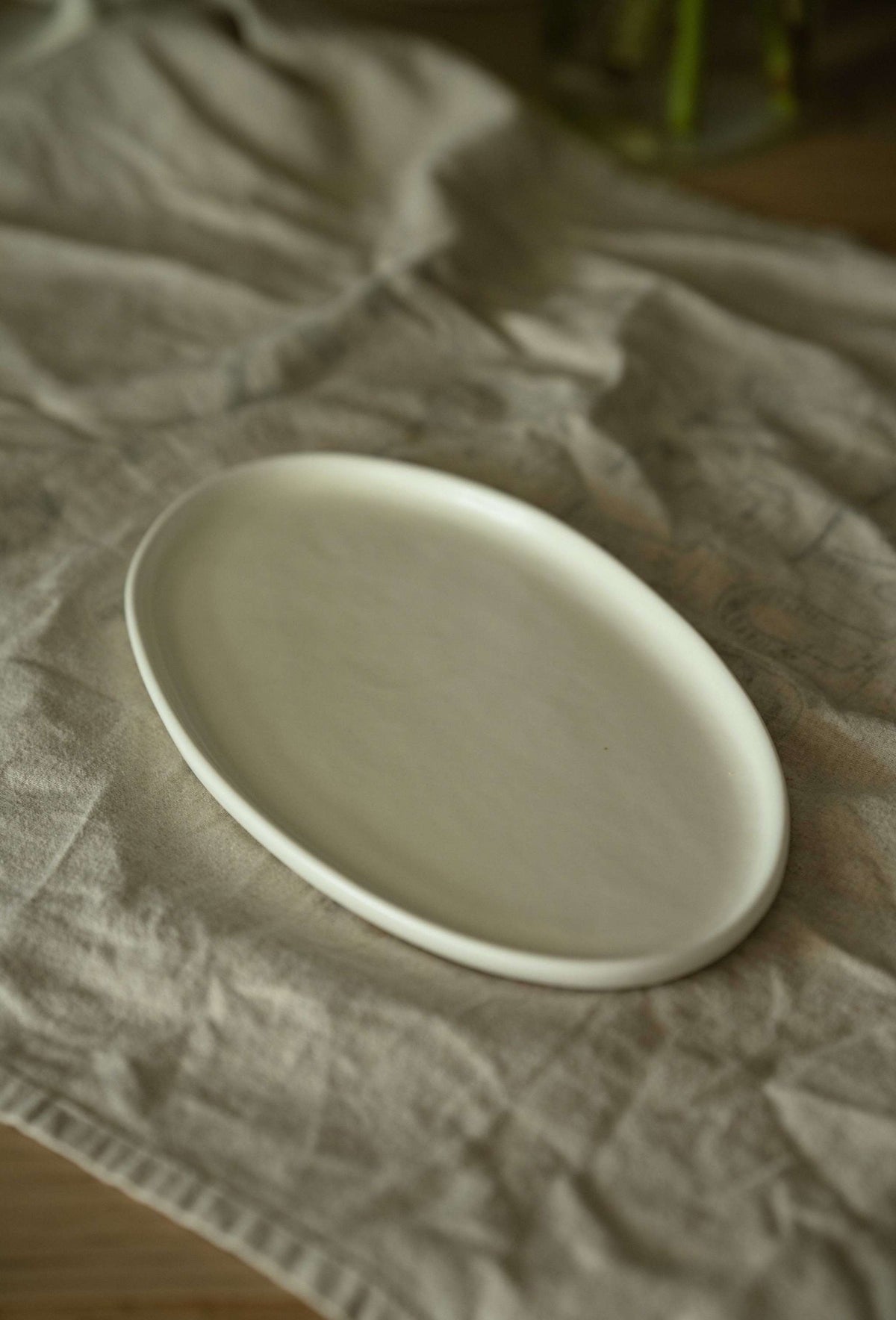 White matte stoneware oval serving platter with organic edges and reactive glaze, handmade in Ukraine