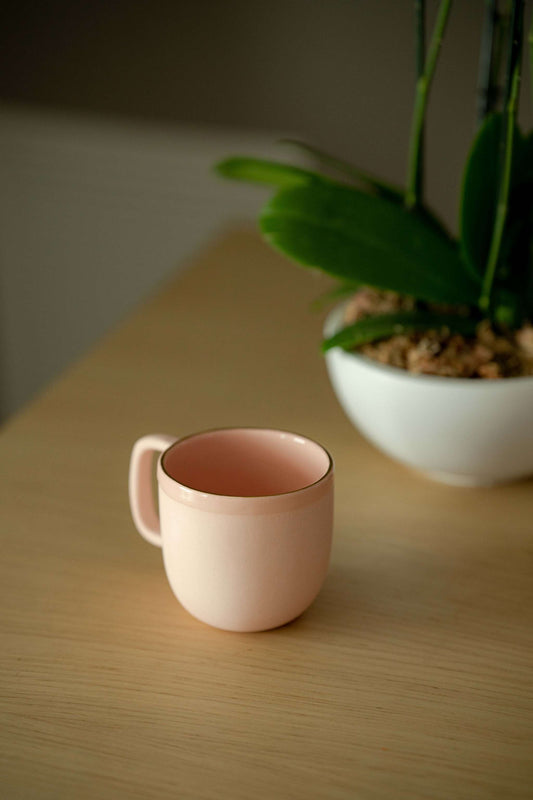 Handmade porcelain coffee mug in powder pink with gold rim and glossy glaze