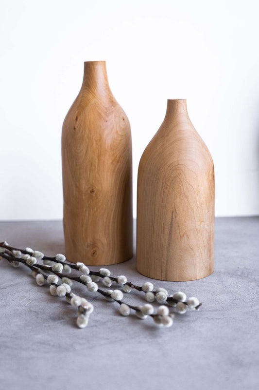 Handcrafted pear wood bottle-shaped vase with natural grain patterns and smooth finish, elegant home decor piece