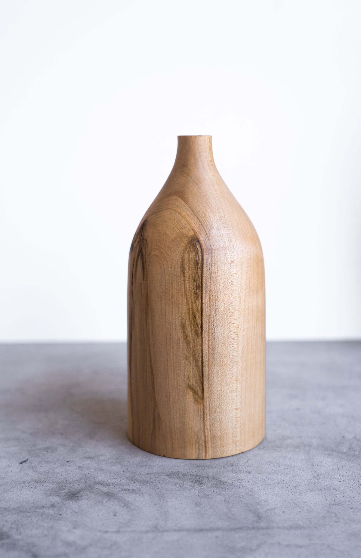 Handcrafted pear wood bottle-shaped vase with natural grain and smooth finish, elegant home decor piece