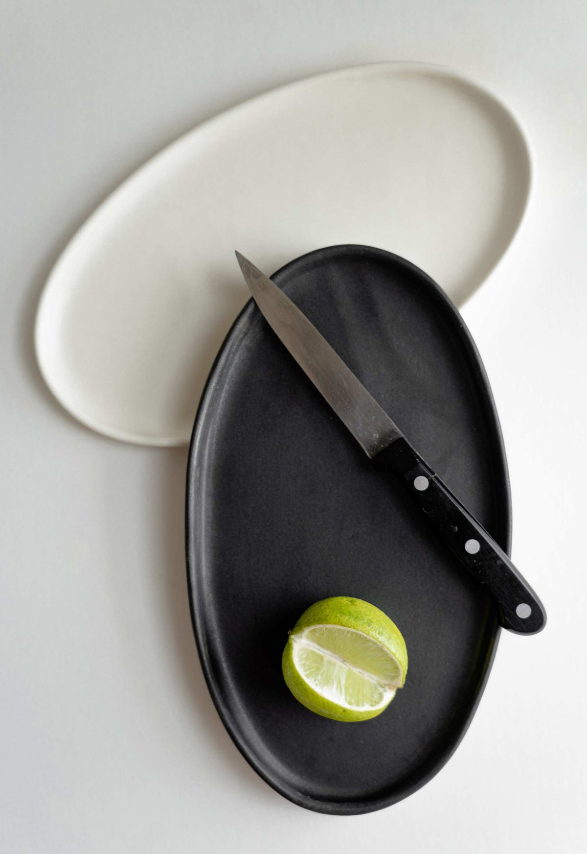 Handmade black matte stoneware oval serving platter with organic edges and reactive glaze