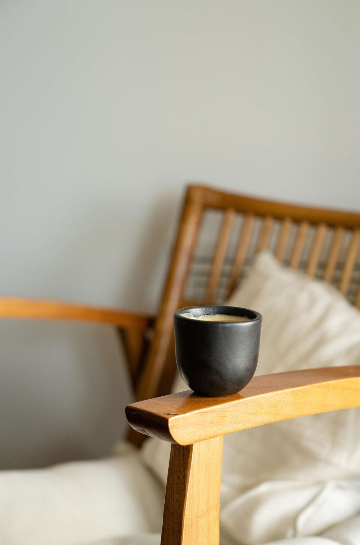 Handmade black stoneware espresso cup with organic edges and reactive glaze